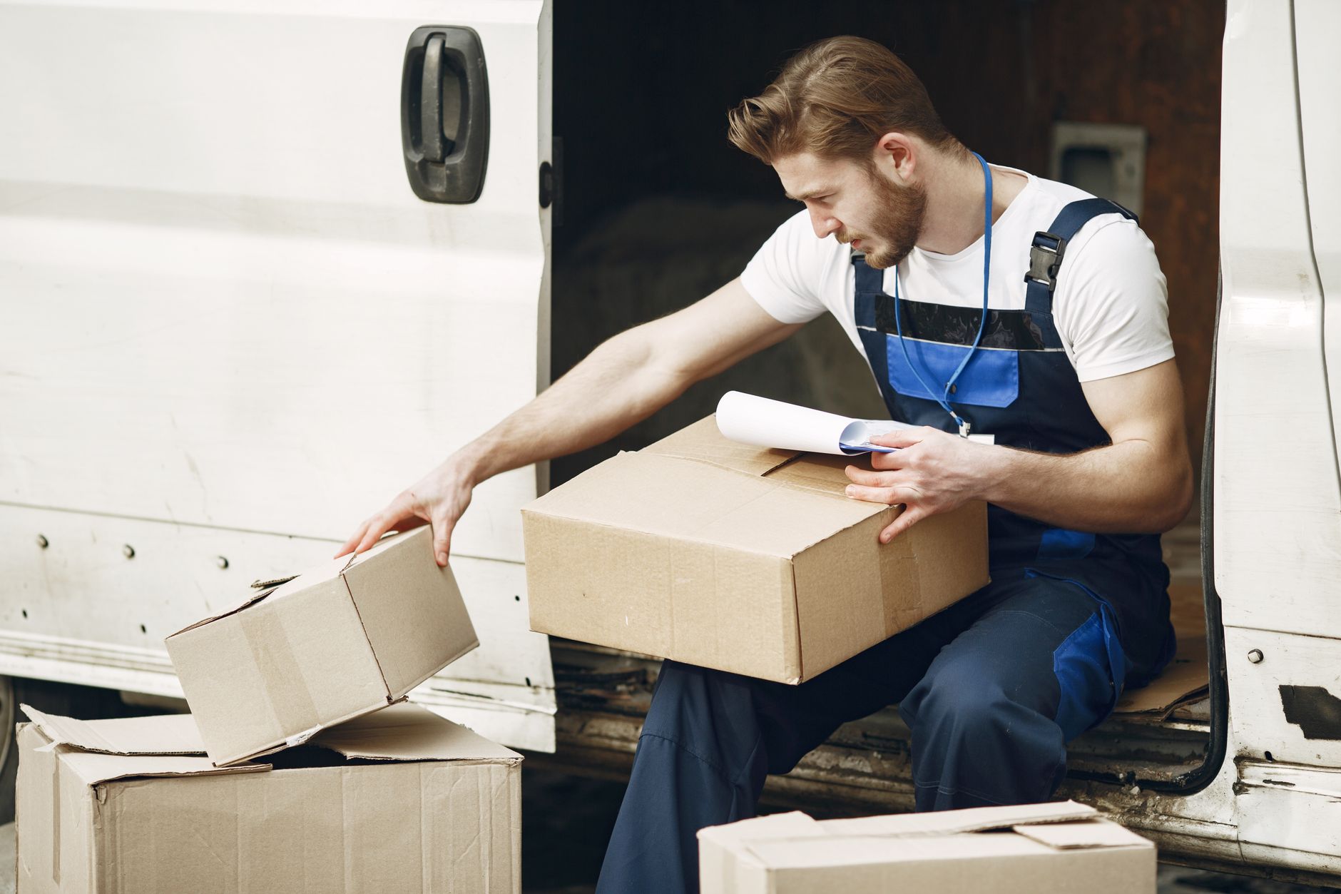 A person works at a packing station, performing the kind of repetitive motions that can lead to costly musculoskeletal disorders in a factory setting.