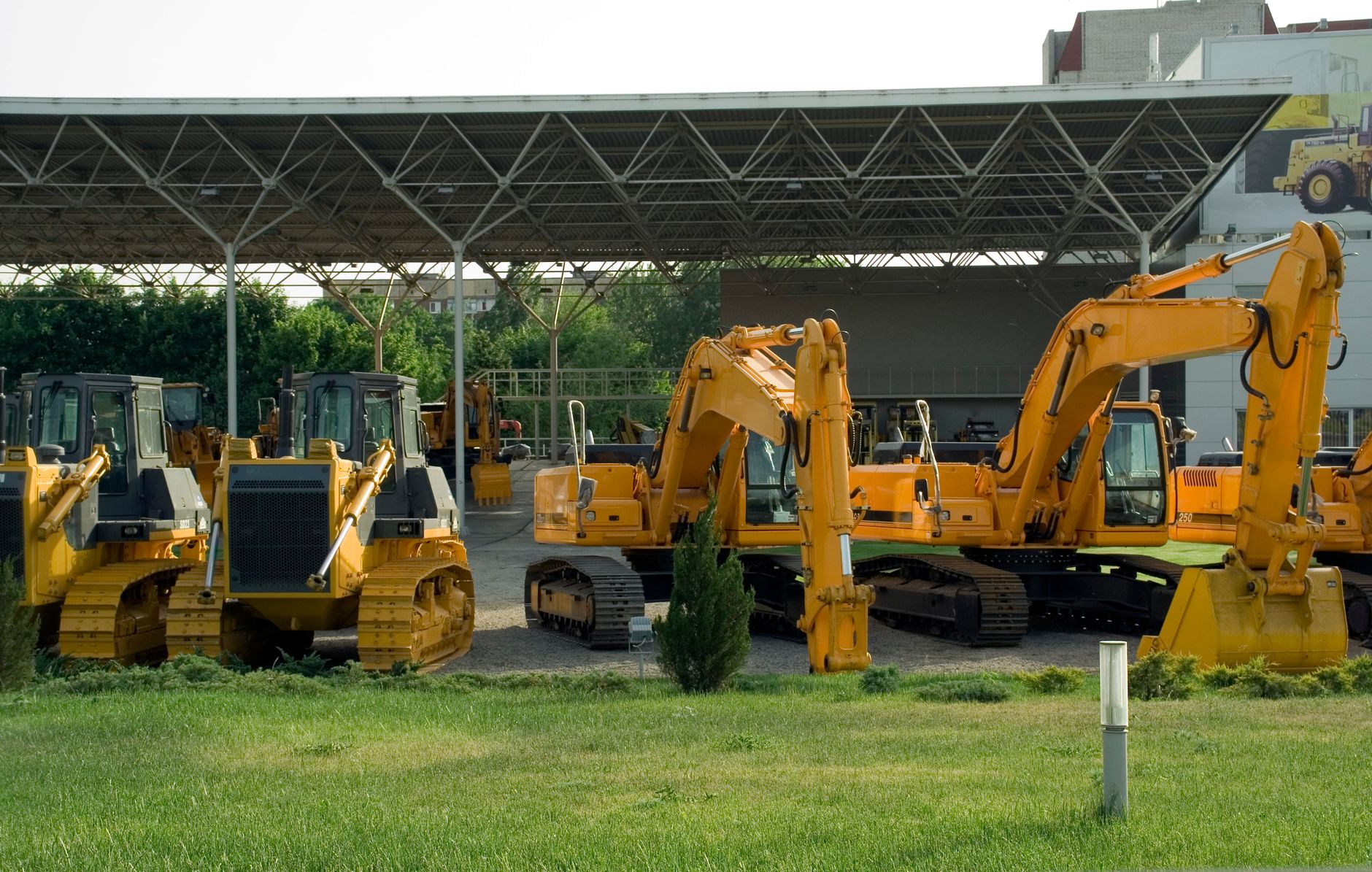 Rows of construction lifts and compact equipment staged in an outdoor rental yard at dusk, the environment patrol programs must cover.