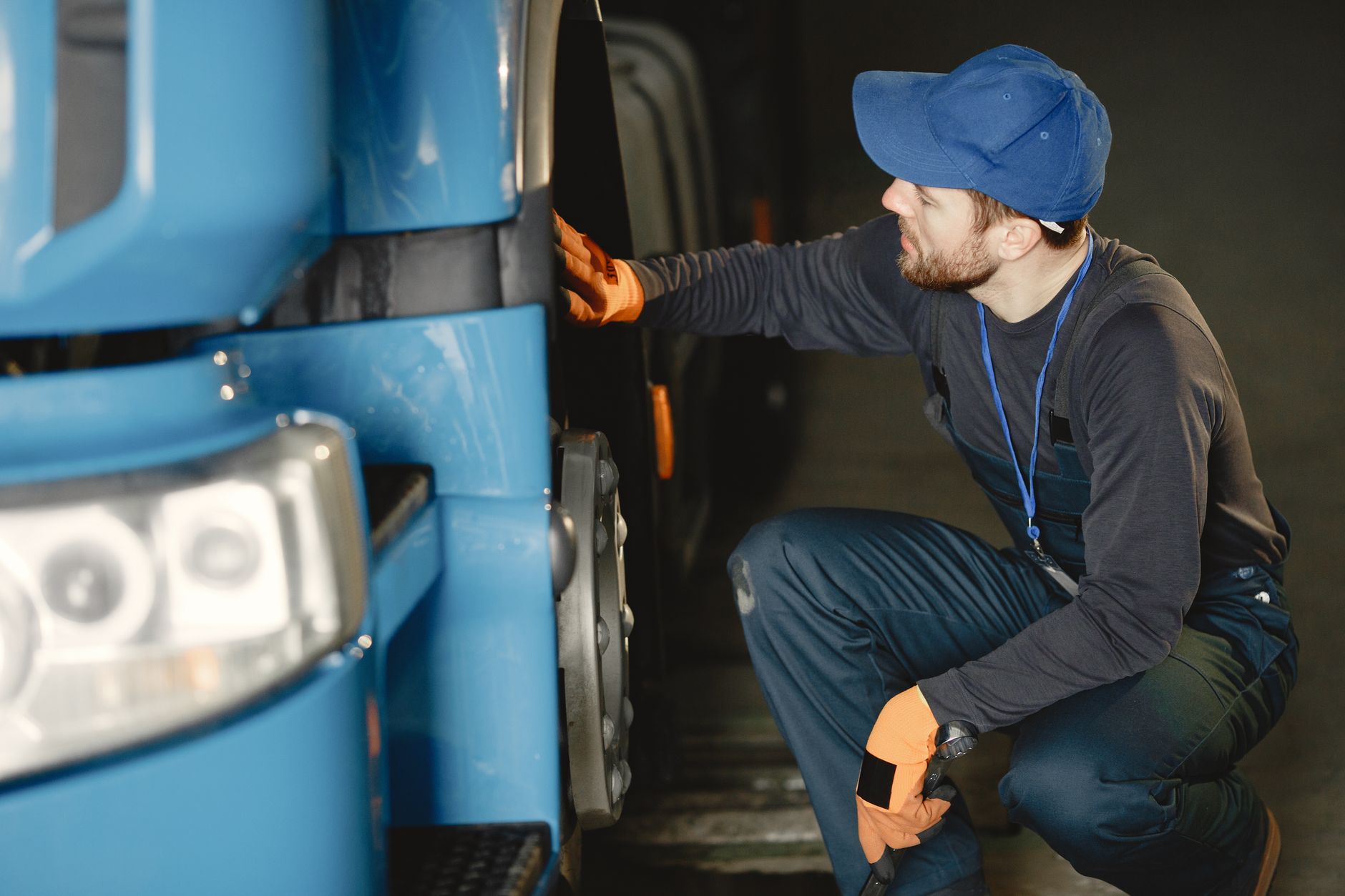 A worker conducting a documented safety inspection beside a parked trailer.