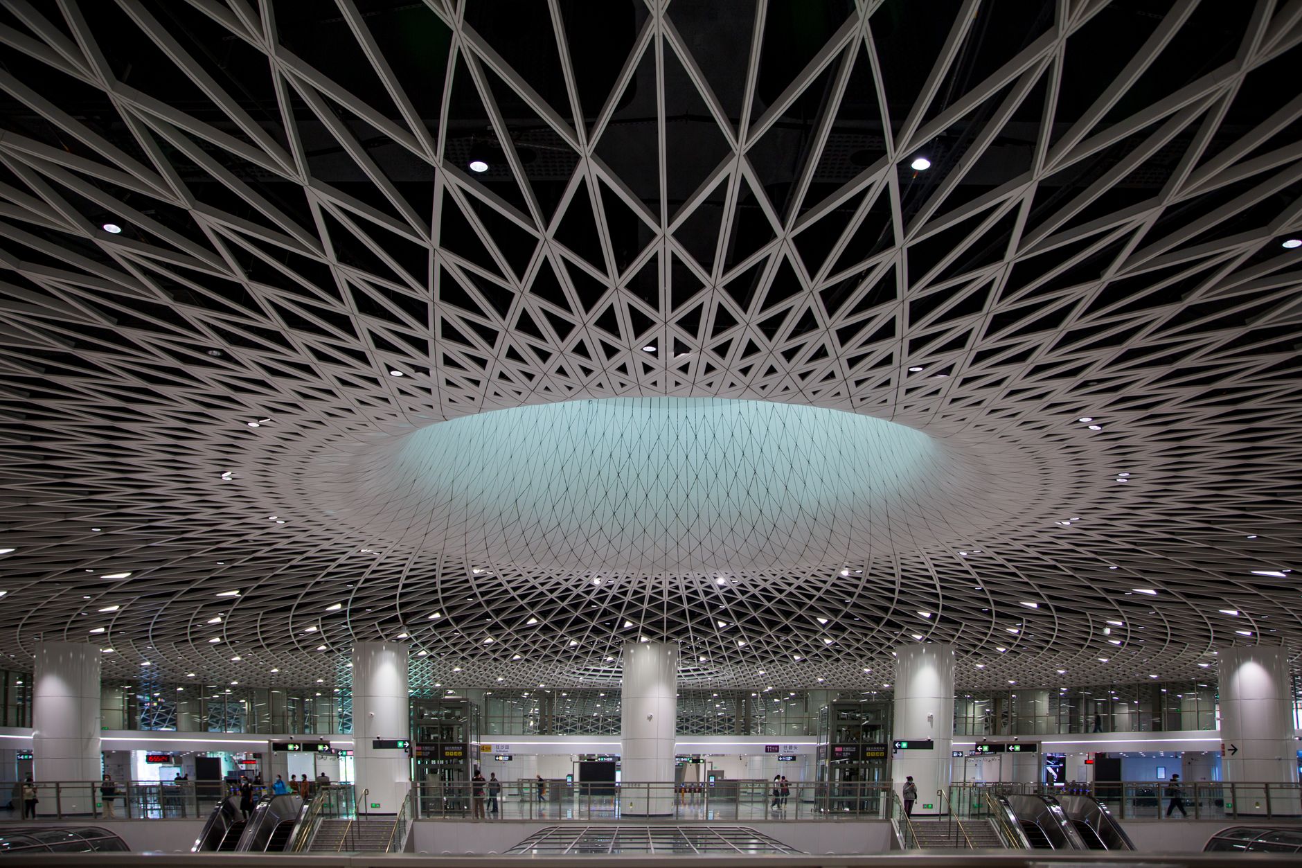 Wide airport terminal concourse with travelers and high ceilings