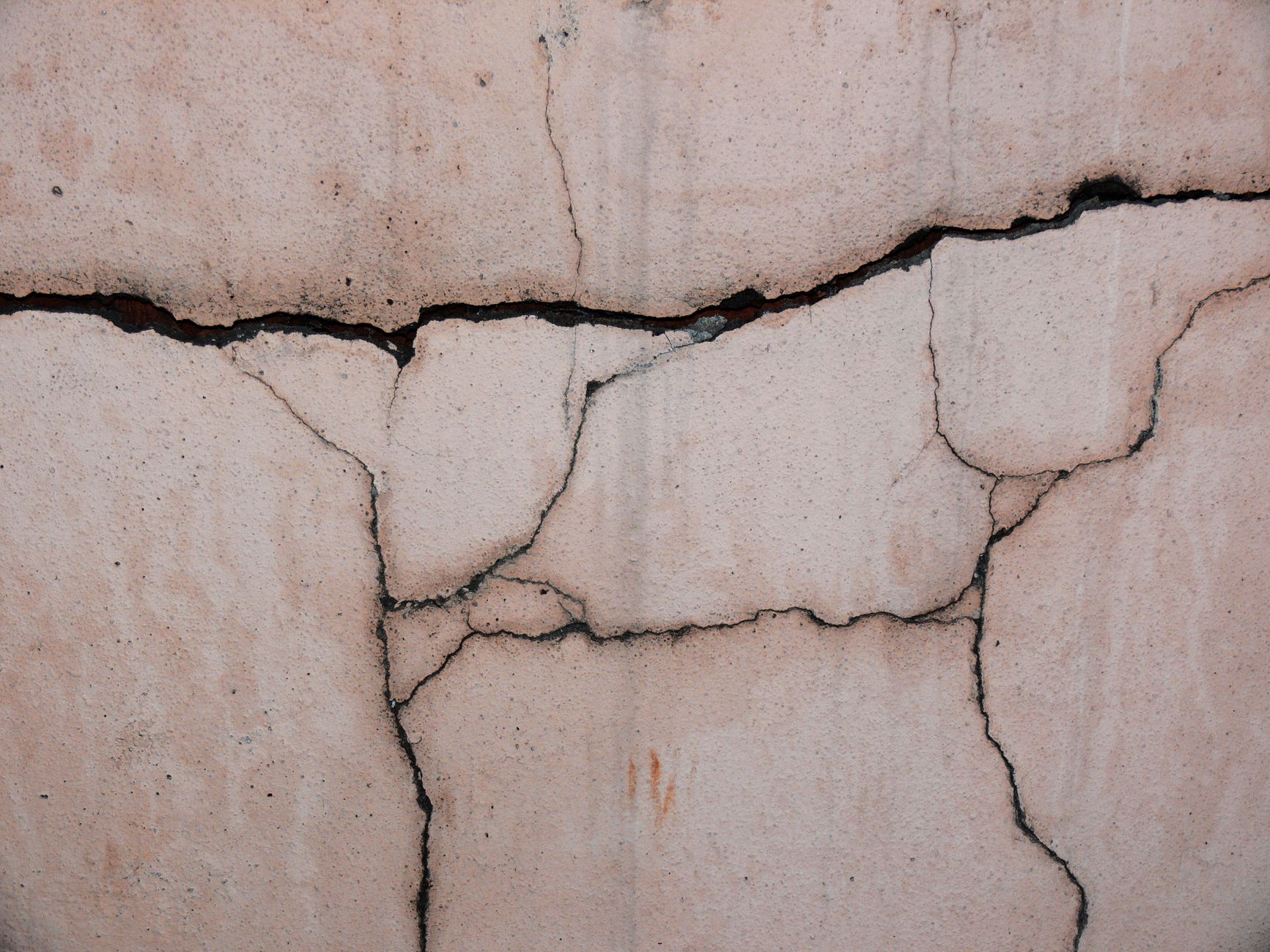 A close-up photograph of a significant crack in a concrete foundation wall, indicating a structural issue a robot inspection would detect.