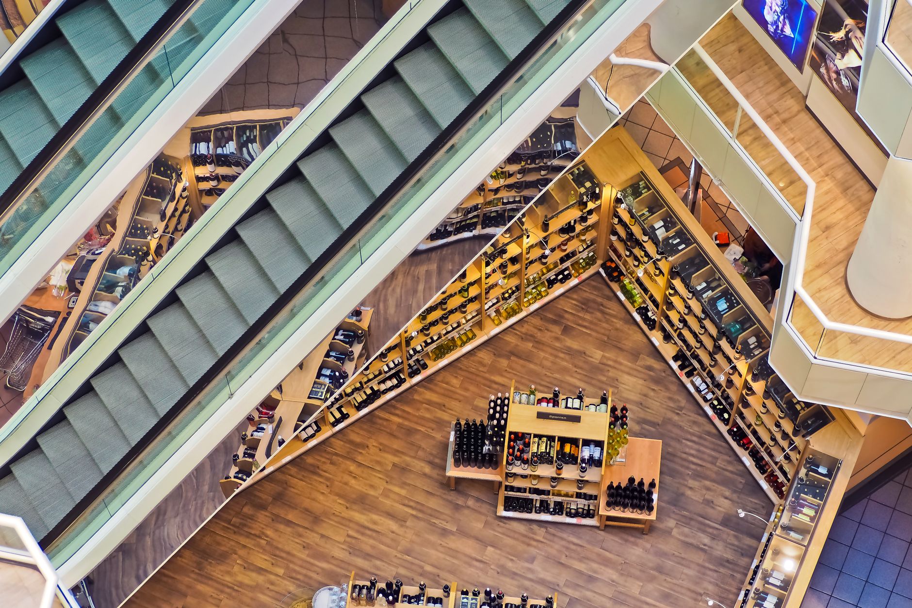 A yellow 'wet floor' sign stands next to a puddle on the floor of a brightly lit grocery store, highlighting the slip-and-fall risk the article addresses.