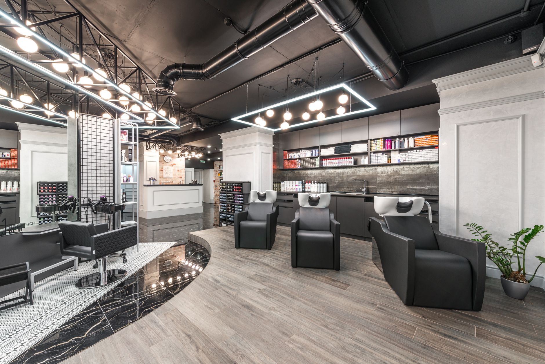 Empty hair salon floor with styling chairs and mirrors after closing time.