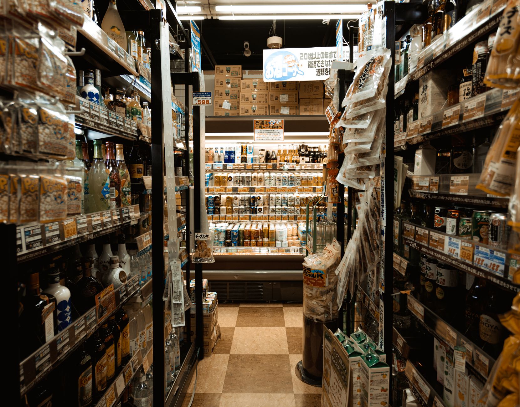 A narrow grocery aisle illustrates the tight floor plates where small-site robot pilots must prove task reliability instead of volume metrics.