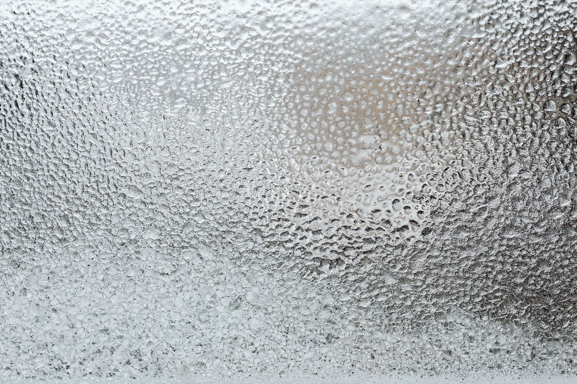 Frost and moisture collect around the threshold of a commercial freezer doorway.