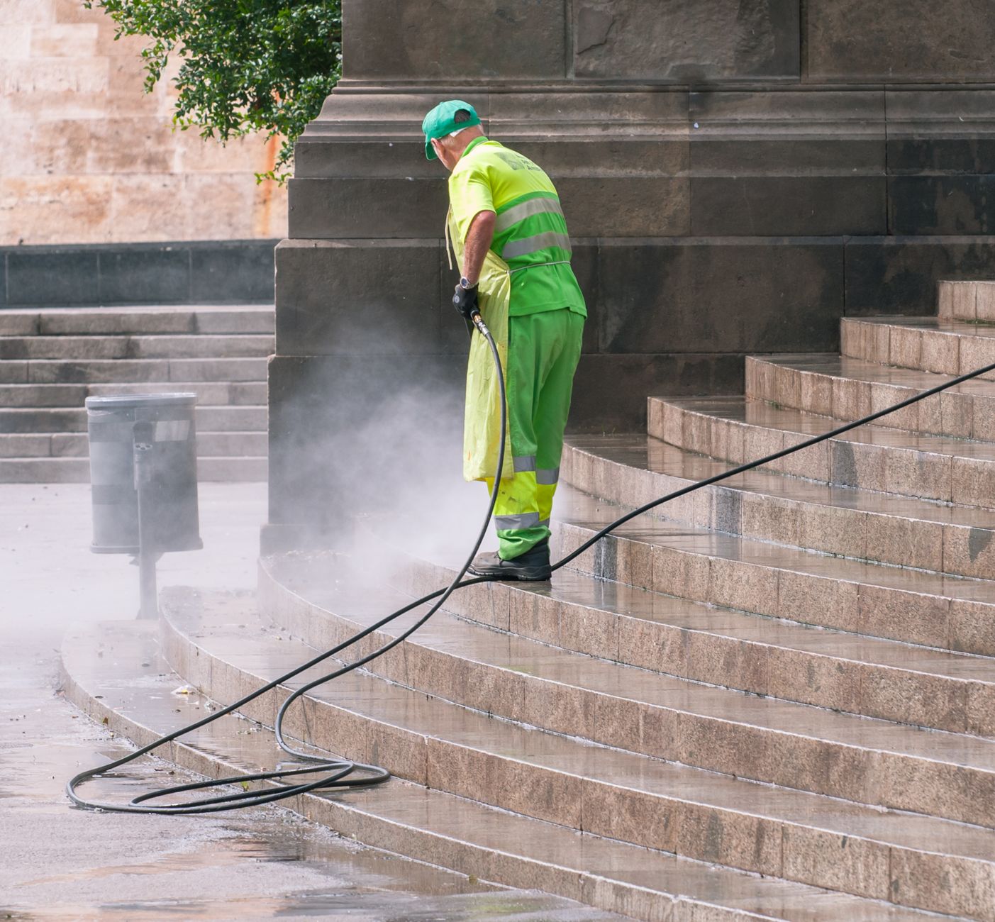Water from a hose splashing onto a durable industrial floor during a washdown, highlighting water usage in cleaning.