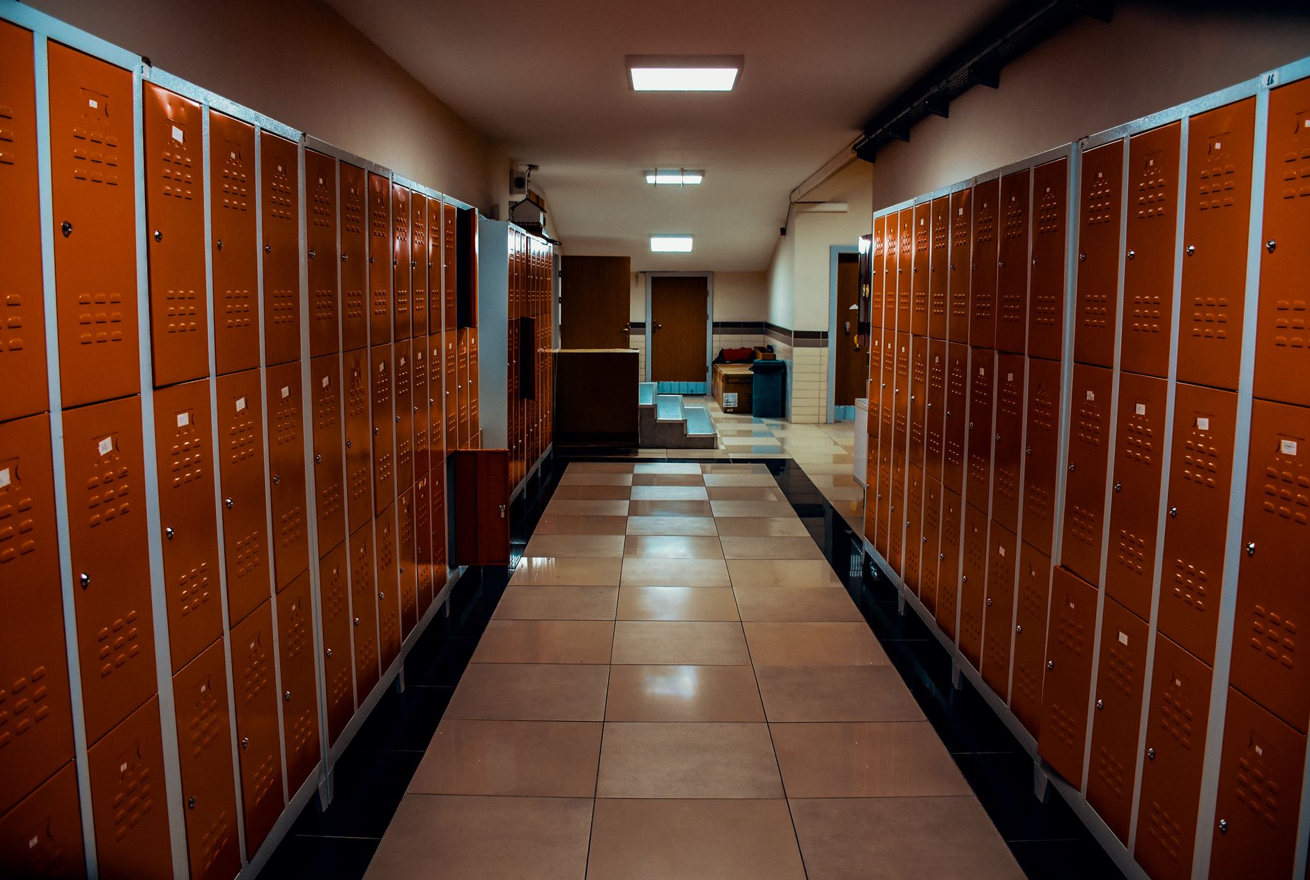 A long service corridor beside team spaces in an arena, showing the kind of hard-floor route that benefits from repeatable overnight cleaning.
