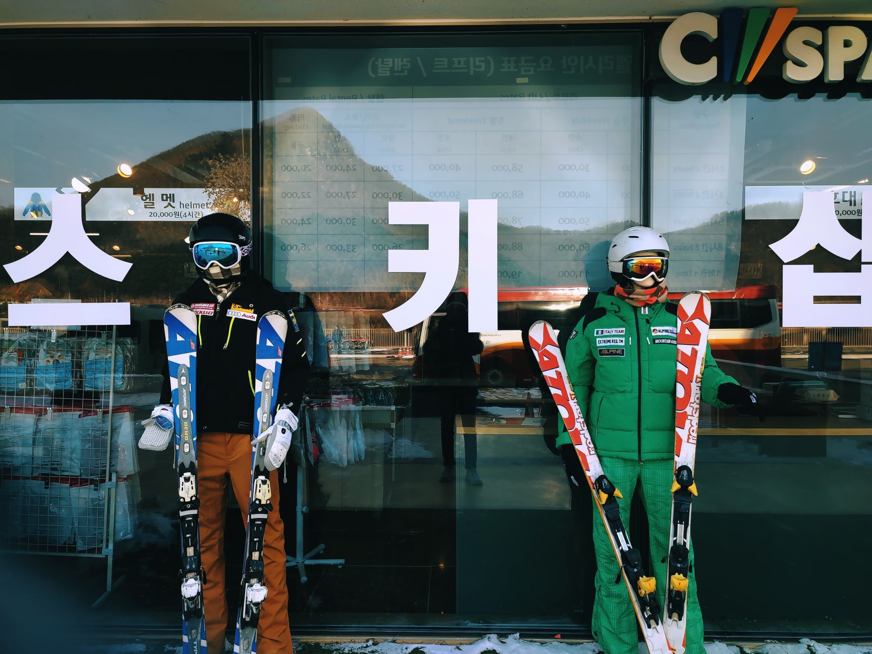 A busy ski rental shop with boot racks, equipment, and narrow customer aisles.