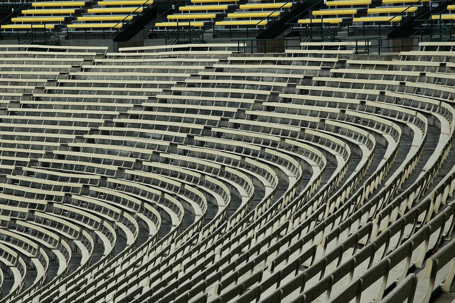 Rows of empty bleachers beside an indoor sports hall floor.