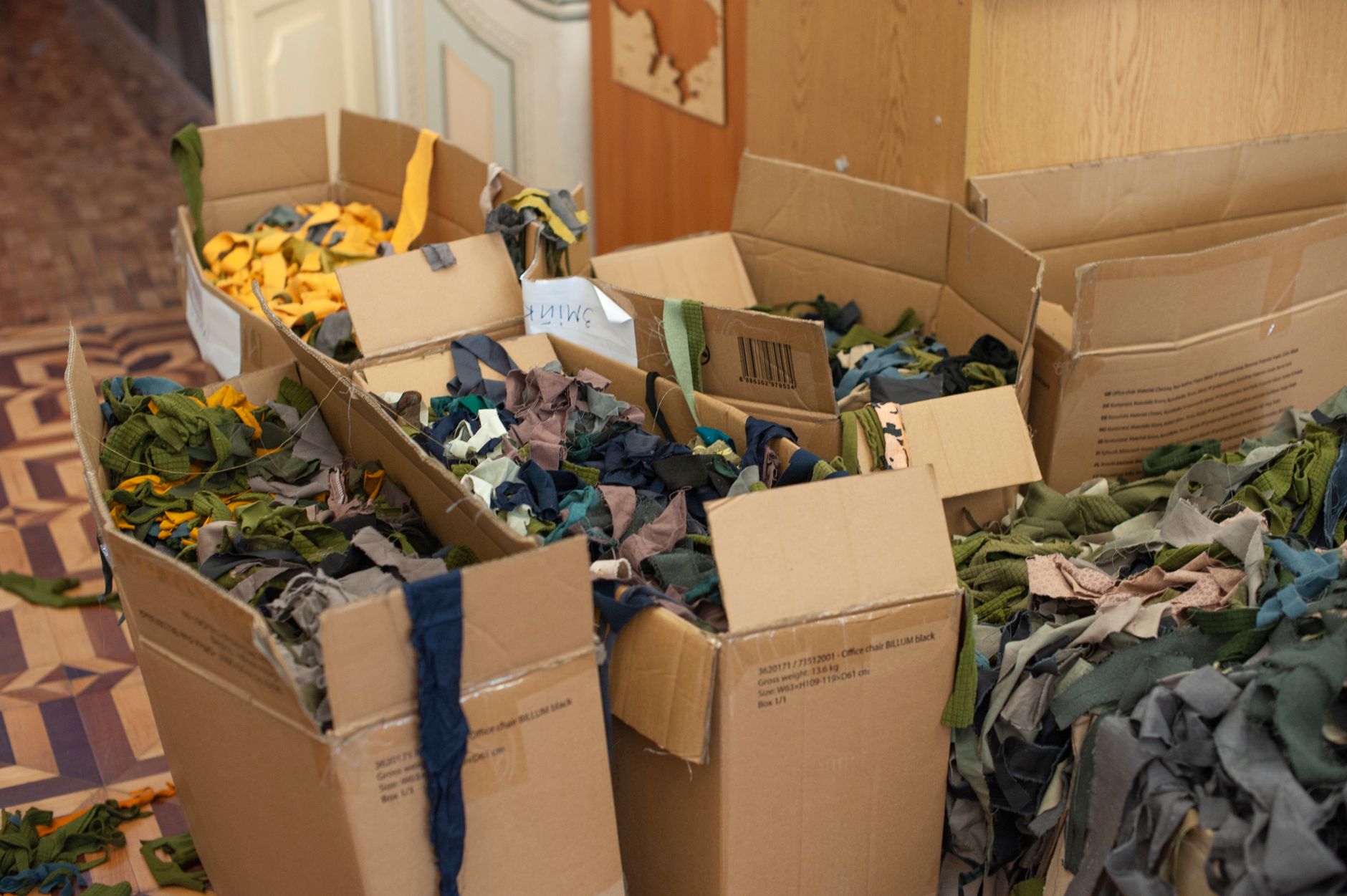 Small cardboard fibers and packing scraps scattered across a hard commercial floor.