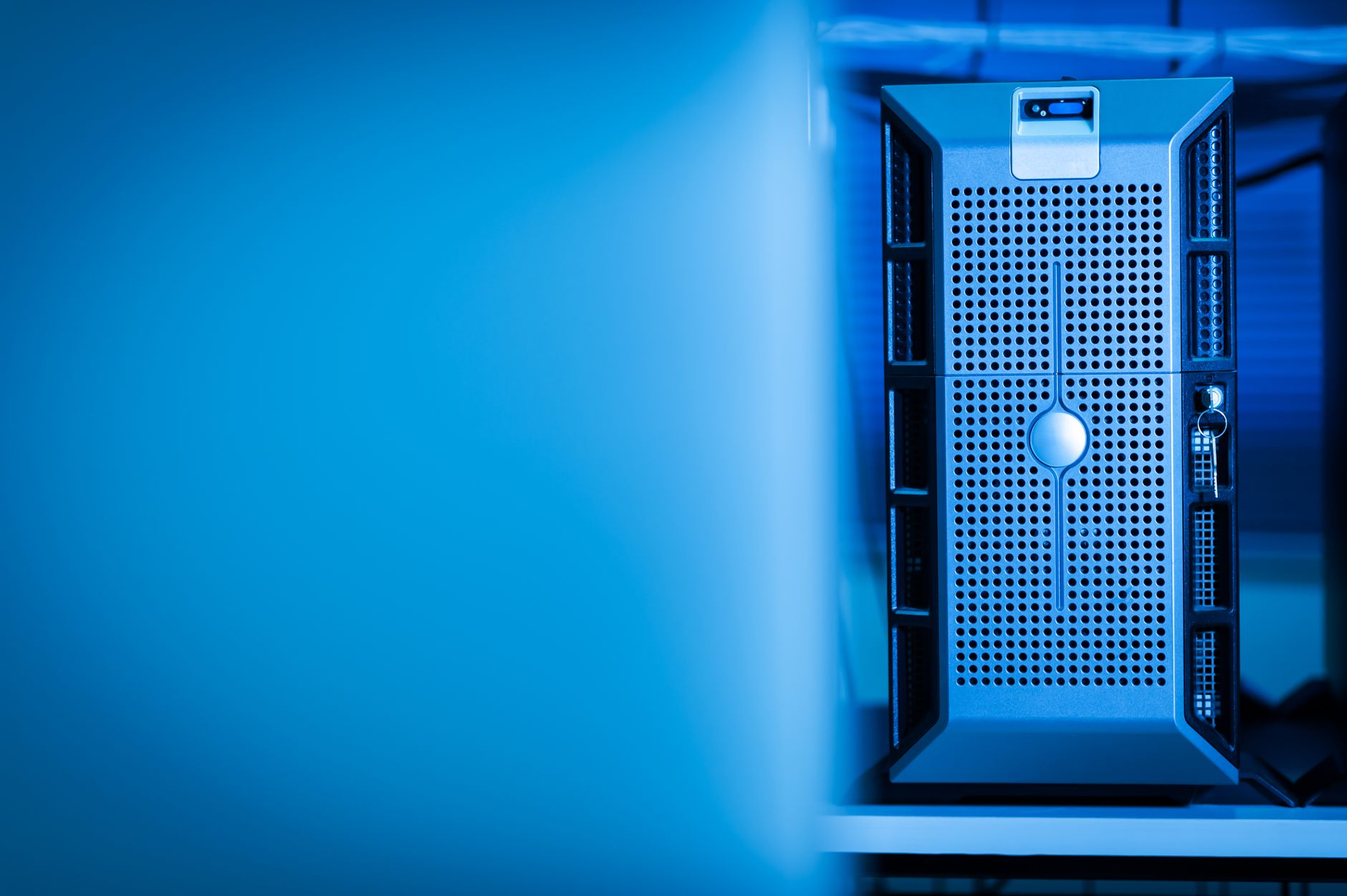 A long, clean aisle in a modern data center, lined with rows of glowing server racks.