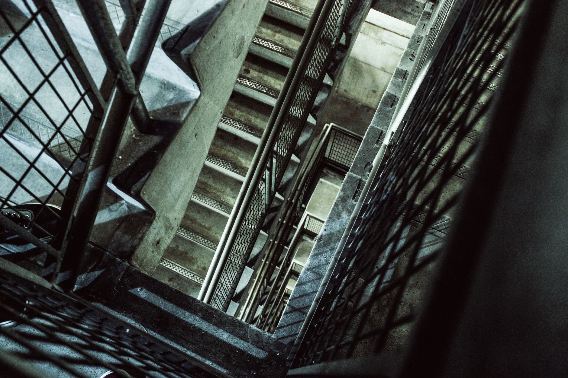 Concrete stair core with metal railings, echoing the dense structure that can weaken radio links during remote inspection.