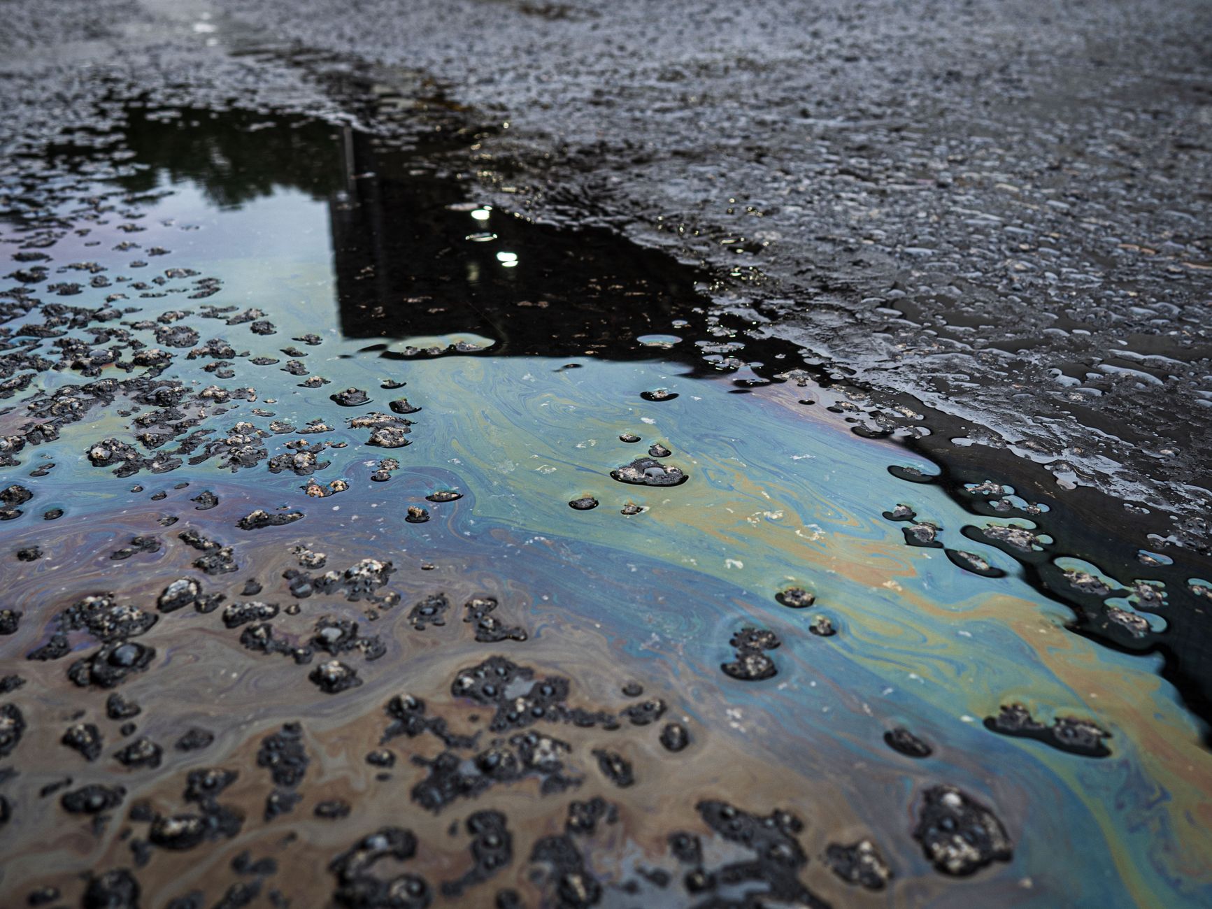 Oil and debris cover an industrial floor, illustrating the traction and contamination hazards inside an escalator pit.