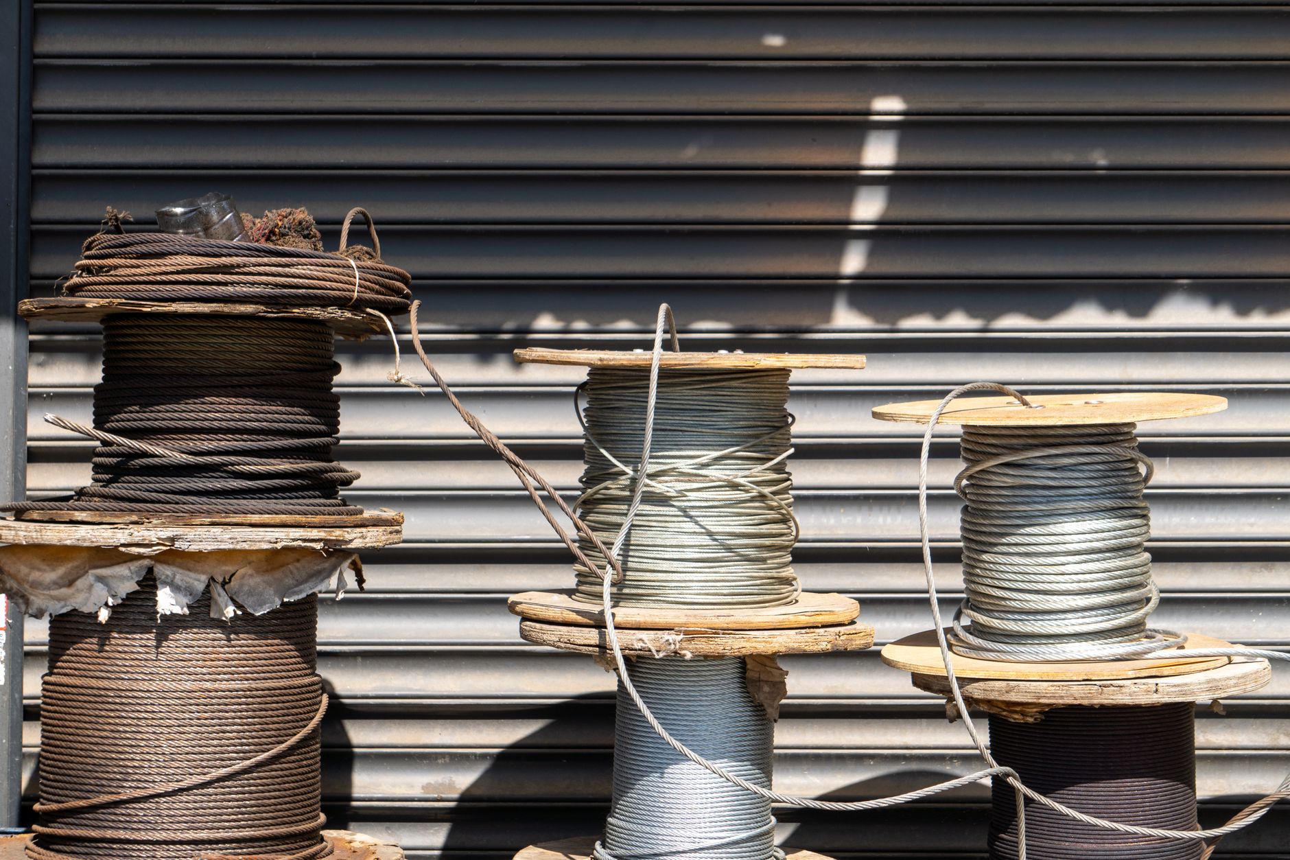 Large copper cable reels staged outdoors, illustrating the theft-sensitive materials often stored in solar equipment yards.