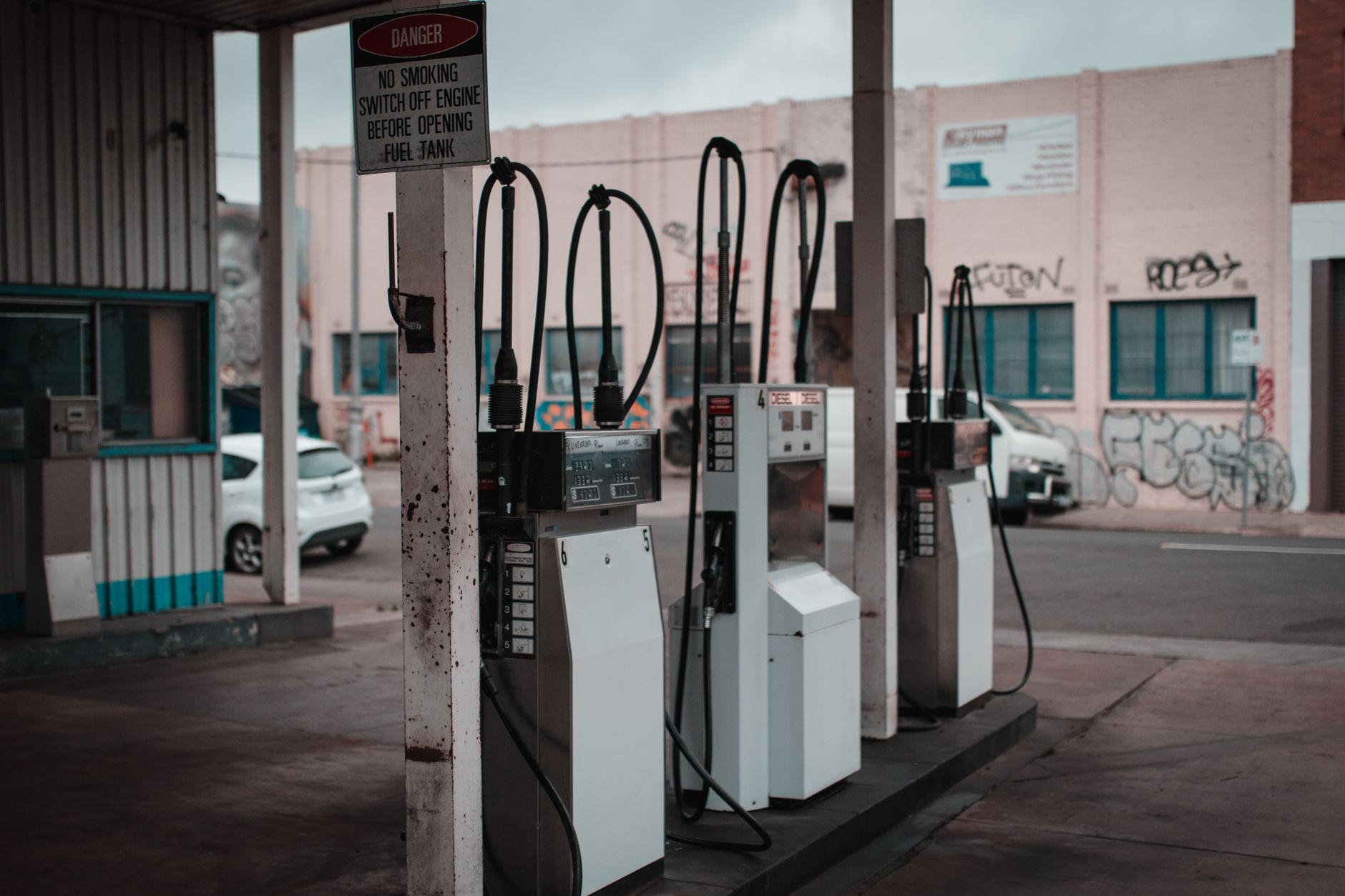 Retail fuel dispensers at a service station forecourt where underground product piping serves each island.