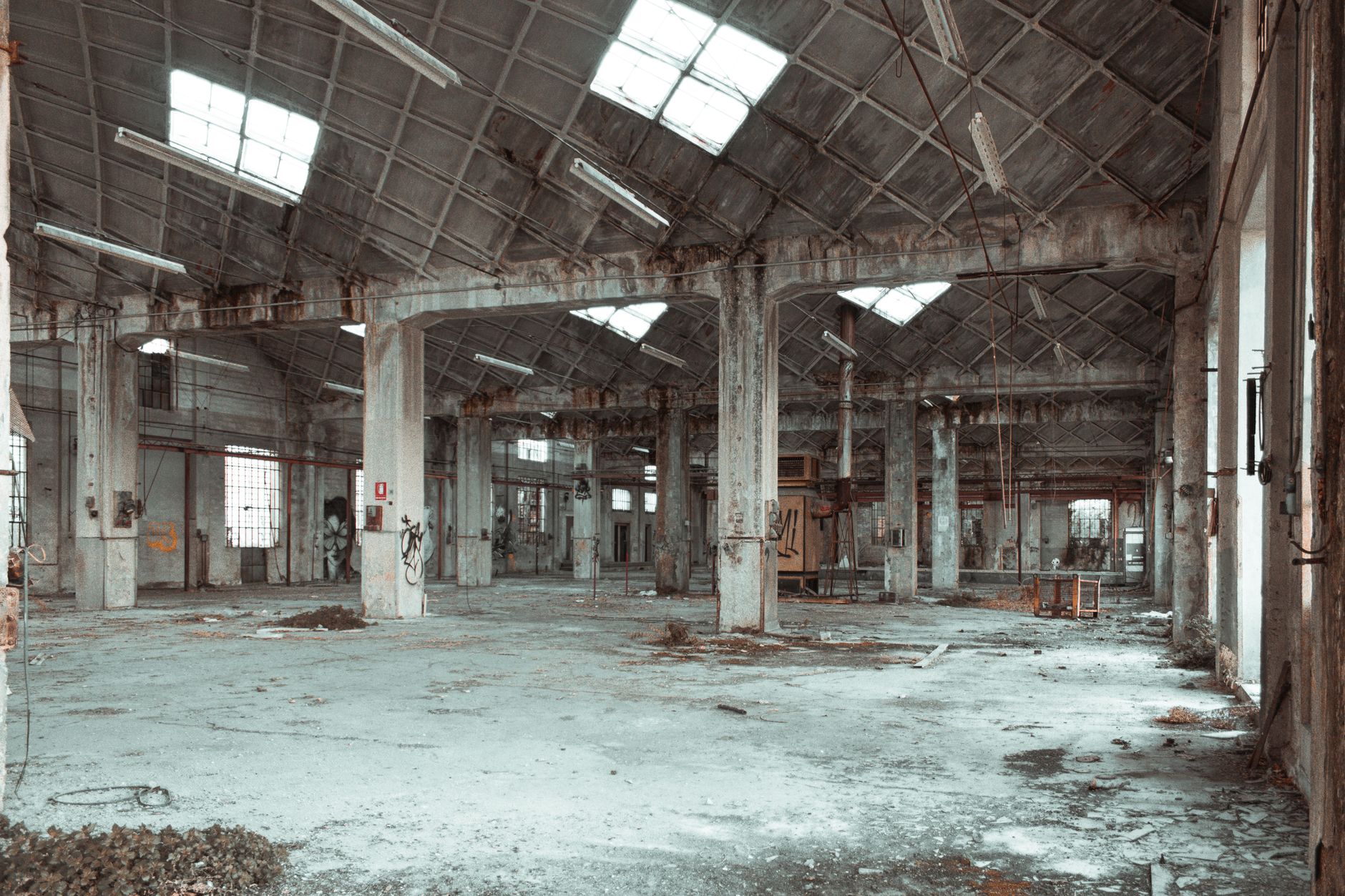 Wide clear-span warehouse bay with overhead structure and rack lines below a contained drone survey.