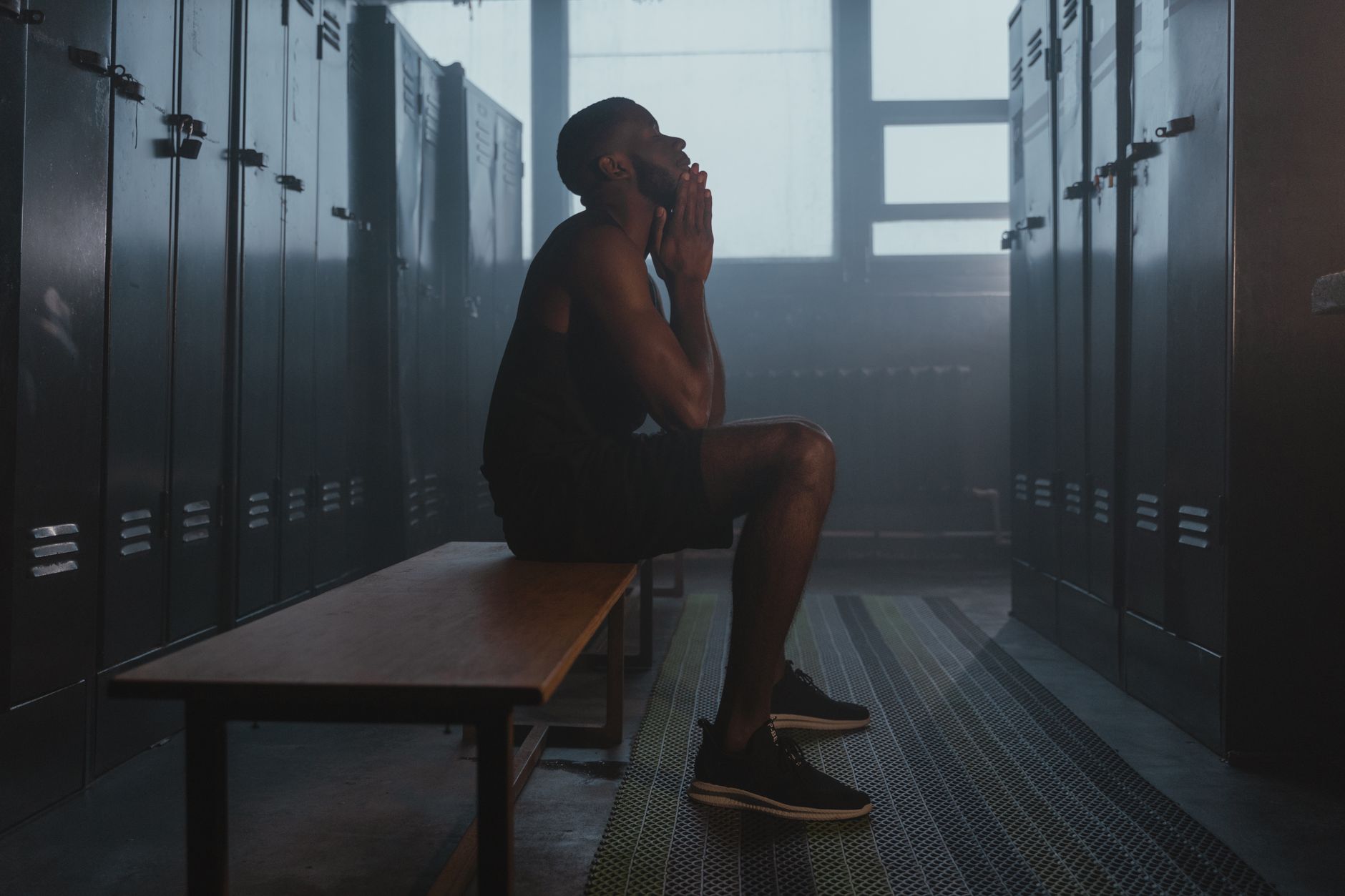 A locker room aisle with benches and tile floors, illustrating why wet thresholds and shifted fixtures often still require manual cleaning in recreation centers.