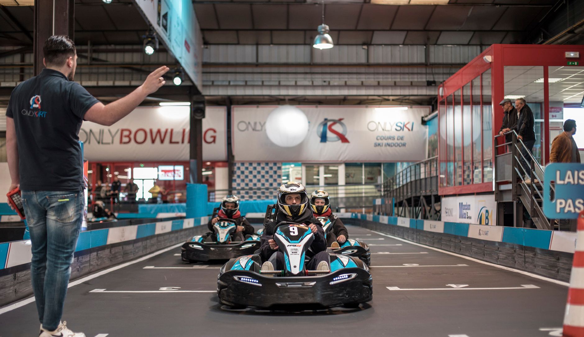 Empty indoor karting track lanes and pit-edge hard floors before overnight cleaning begins.