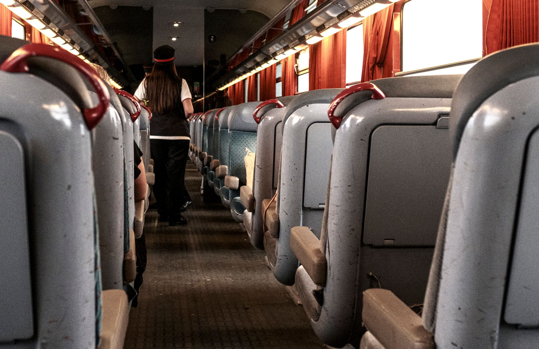 Empty passenger-train aisle and seat rows during an overnight cleaning window.