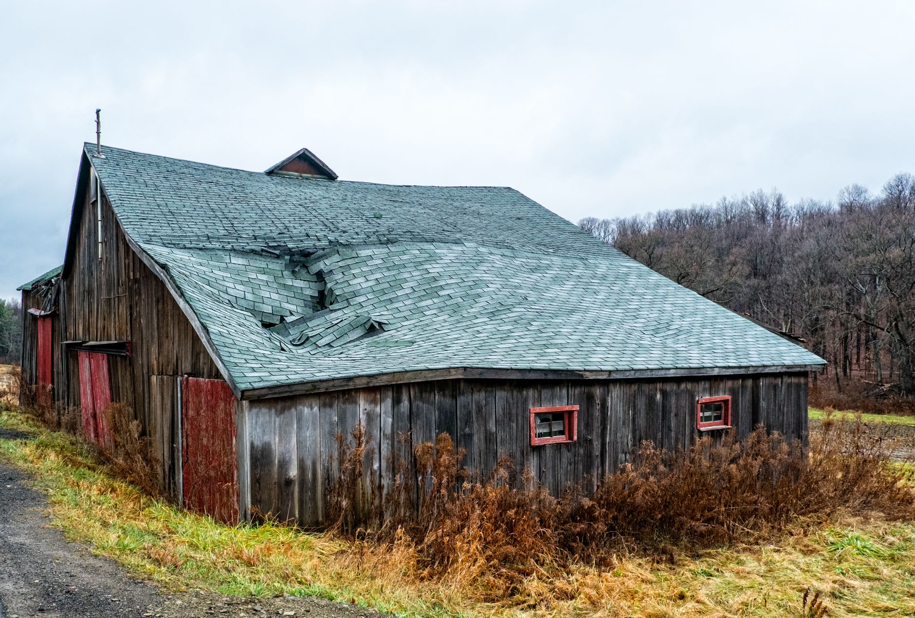 A broad view of roof damage on a large building, showing the kind of exterior conditions a first storm survey needs to capture.