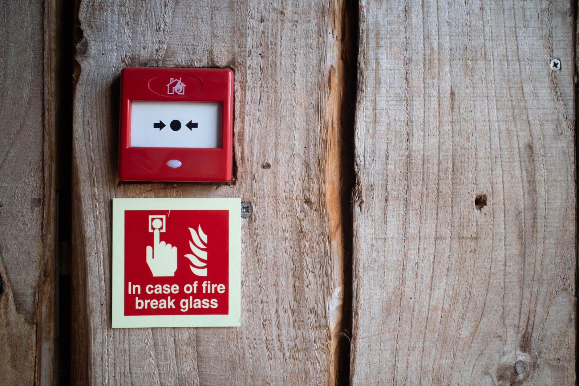 A technician works at a fire alarm control panel while the life-safety team manages an authorized damper test.