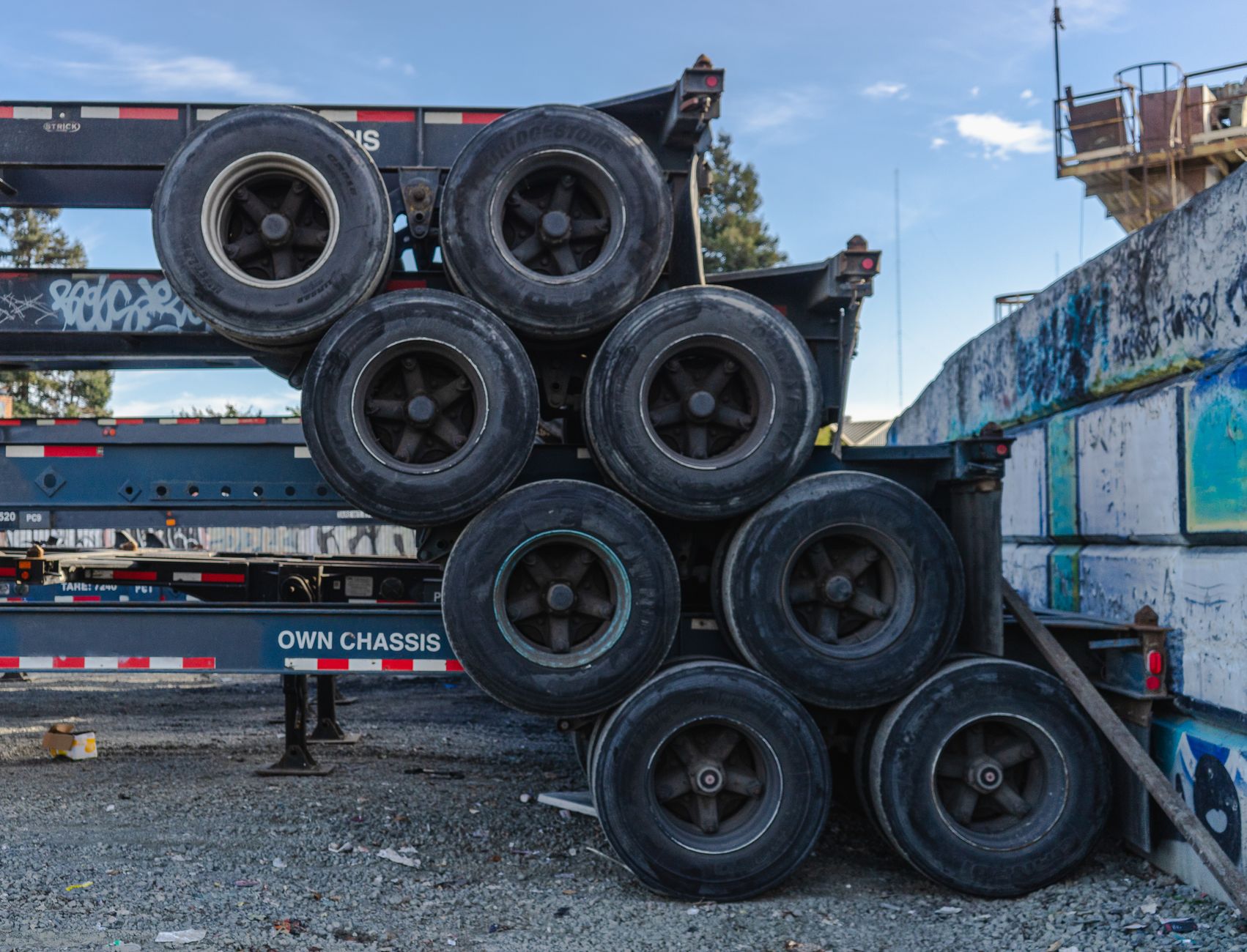 Stacks of commercial tires and mounted wheels show the varied sizes and surfaces a handling system has to deal with.