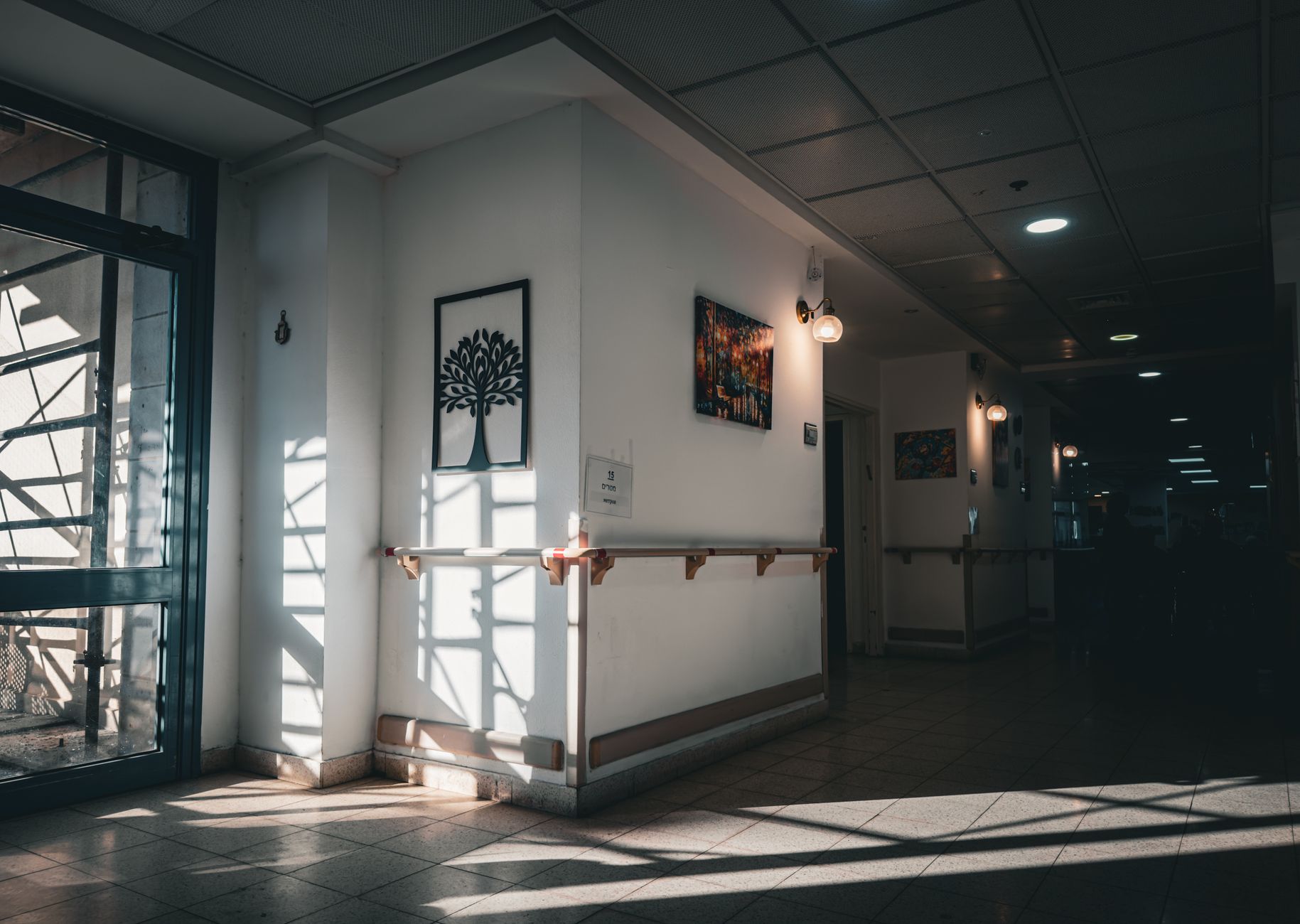 A long, spotlessly clean corridor in a senior living facility, with polished floors reflecting the overhead lights.