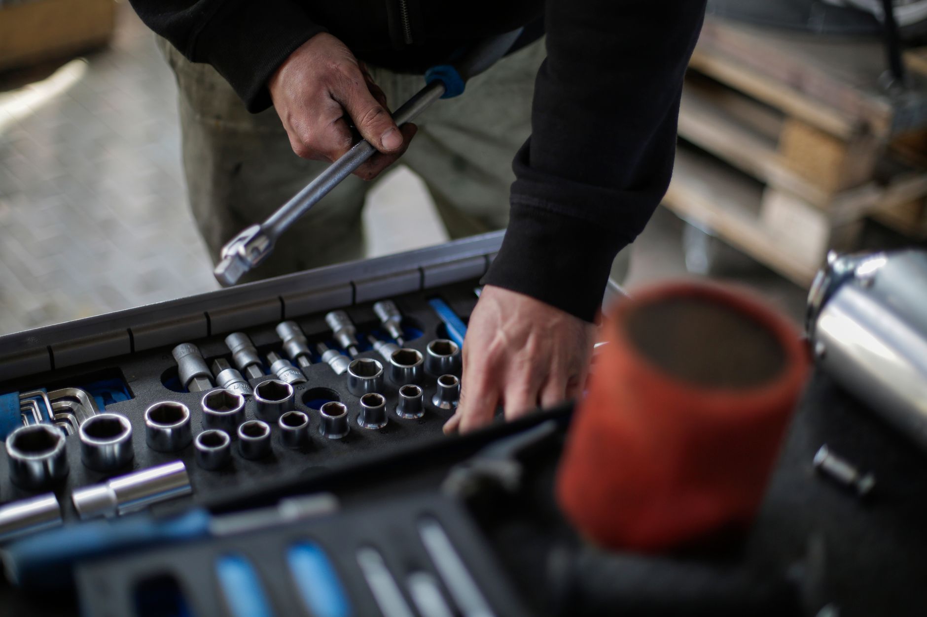 A service engineer stands with a cart of tools in a clean, industrial setting, representing the proactive maintenance required for a 50-robot fleet.