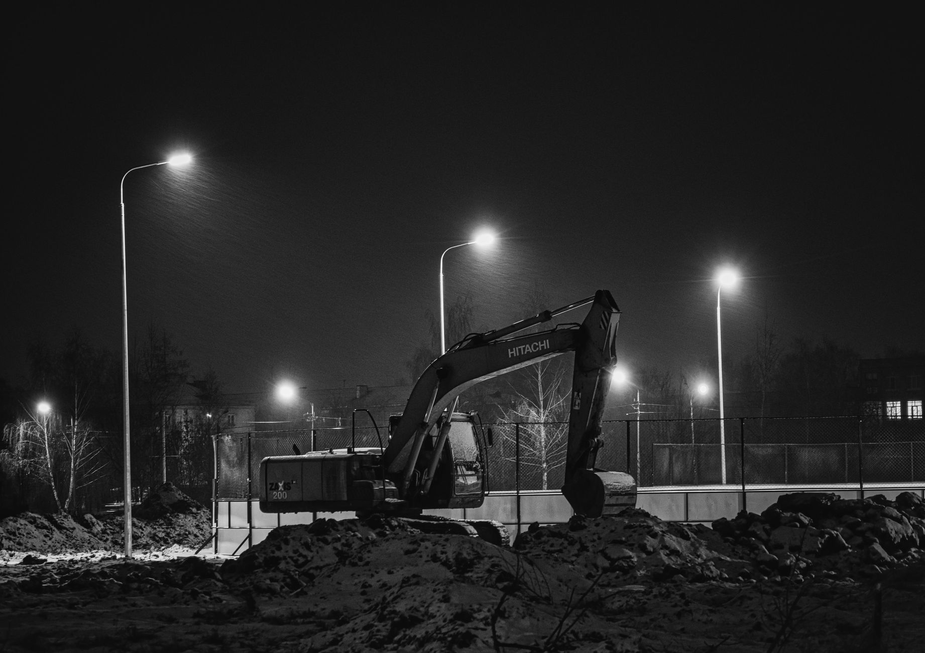 Active construction site at night with temporary lighting, fencing, and unfinished structures that frame the article's focus on after-hours security coverage.