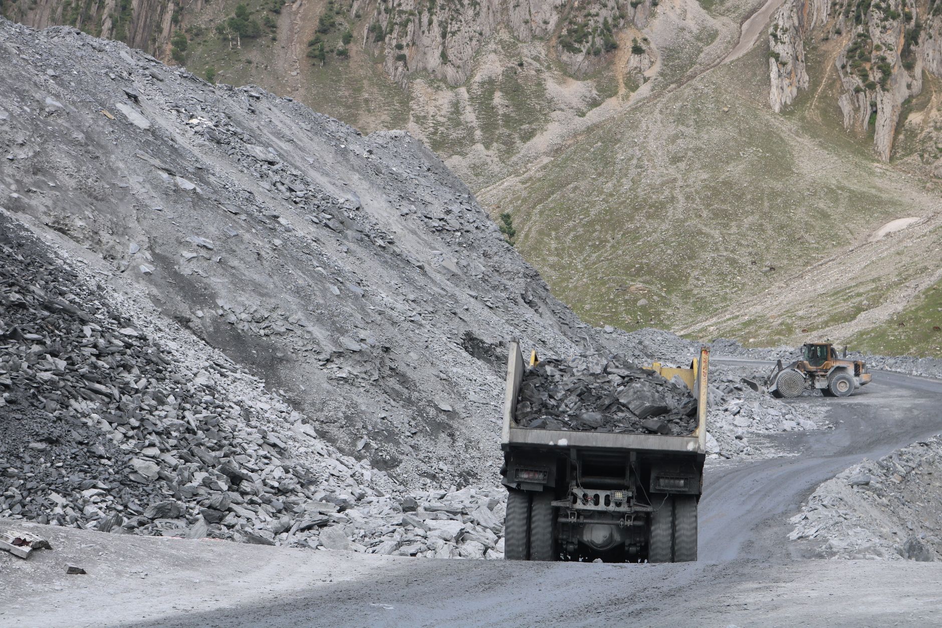 A graded haul road through an open pit area where patrol checkpoints are mapped in daylight.