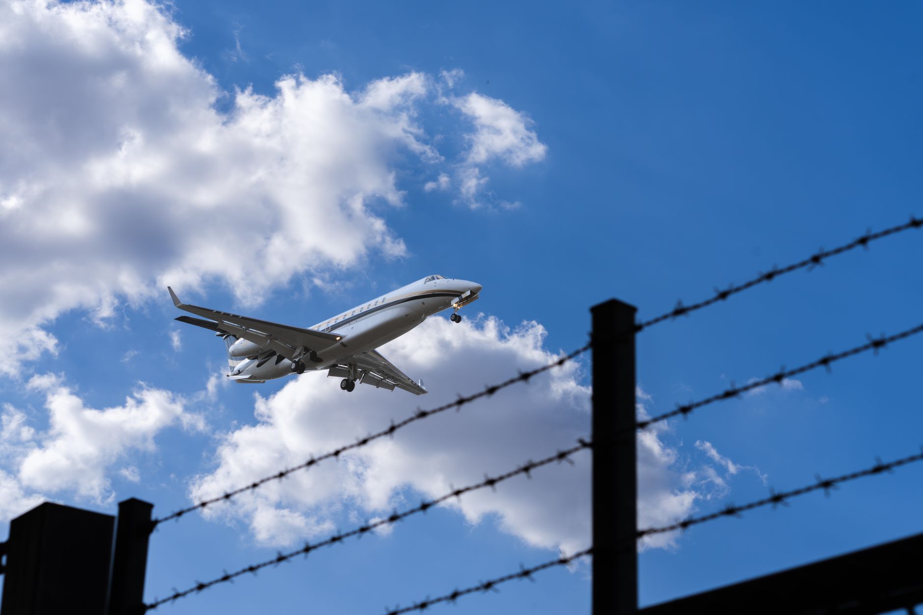Perimeter fencing bordering an airport service area where clear sightlines support security monitoring.