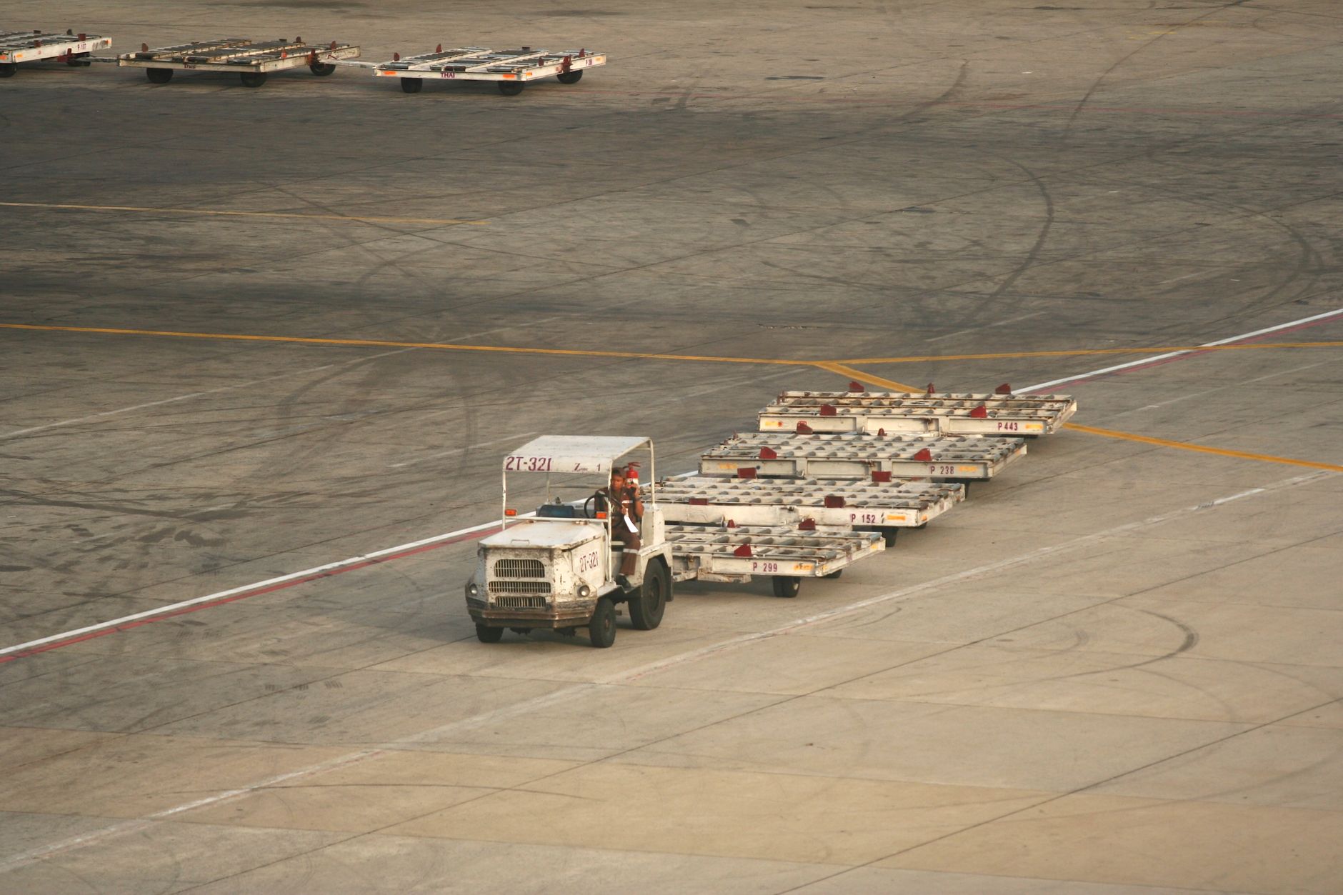 Cargo trucks and ground crews working in a congested airport freight yard.