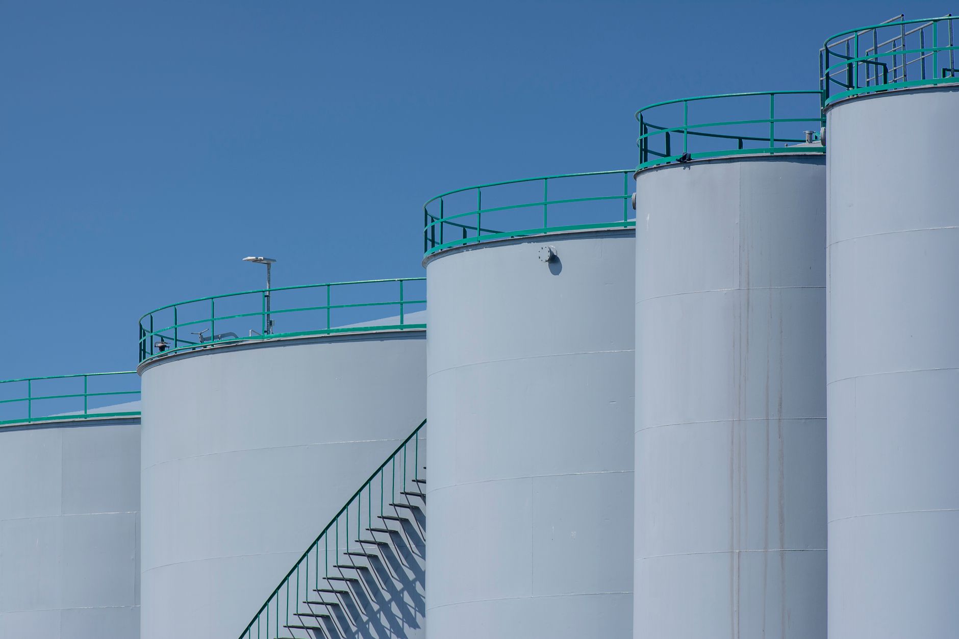 Large fuel storage tanks and pipework at a bulk terminal illustrate the hazardous environment that must be assessed before deployment.