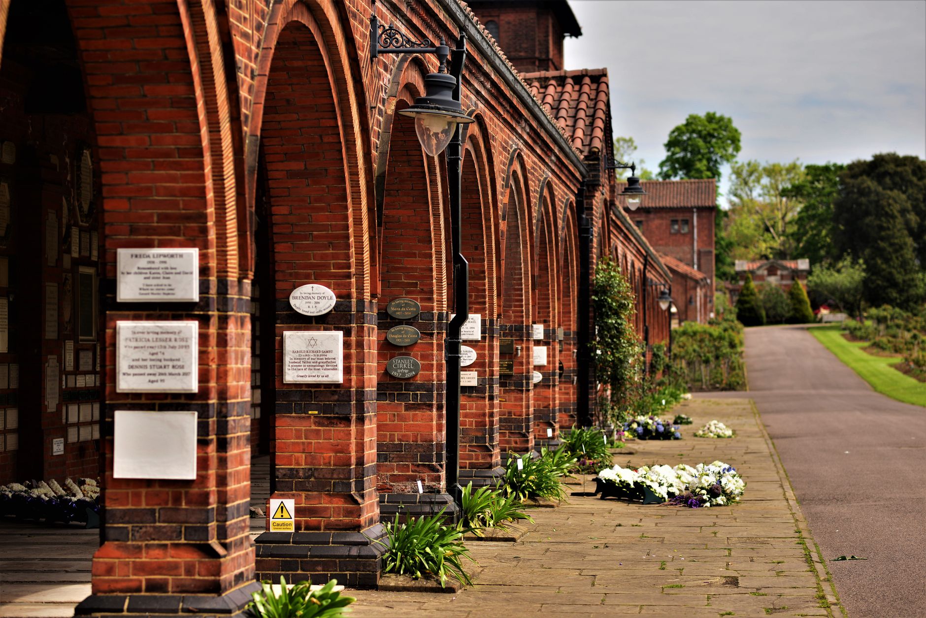 A calm walkway through a memorial garden, reinforcing the quiet and respectful atmosphere visitors expect on cemetery grounds.