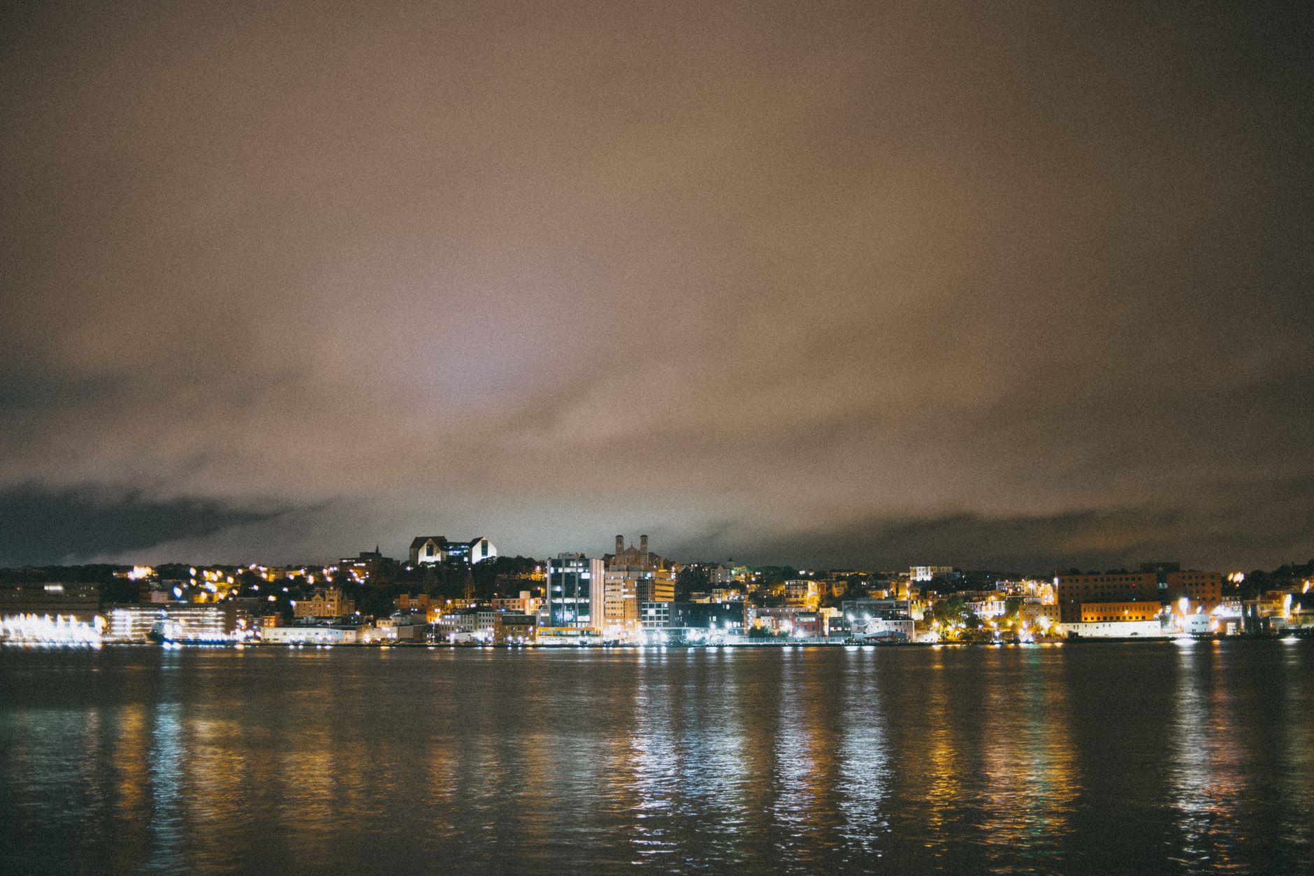Harbor lighting at night with uneven brightness between sheds and outer piers, a common low-light challenge for recorded patrol rounds.