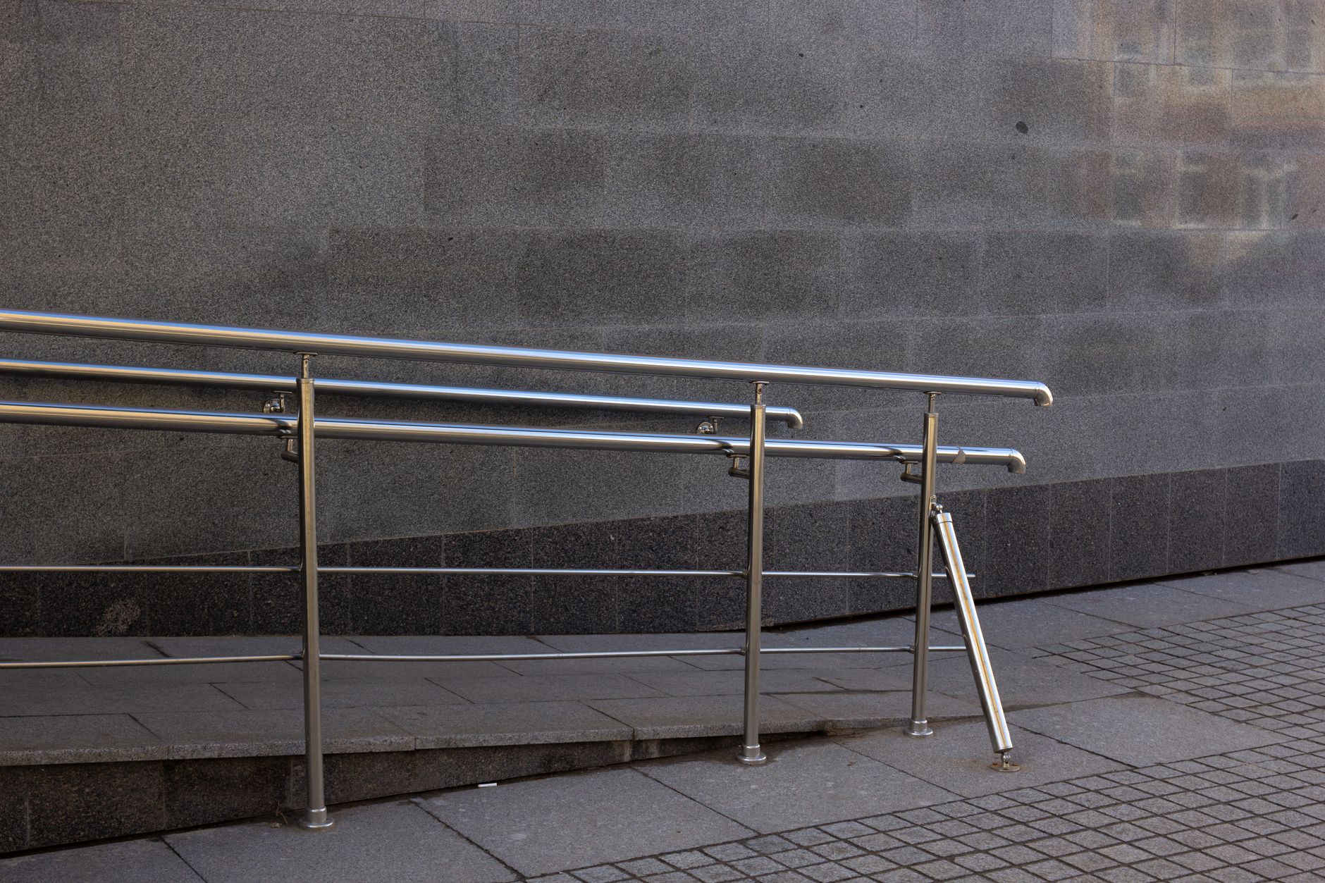 A wide accessible walkway leads toward a public venue entrance.