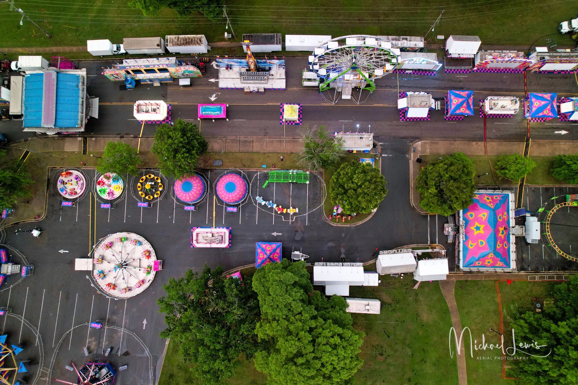 Closed fairground gates overlook quiet grounds between scheduled events.