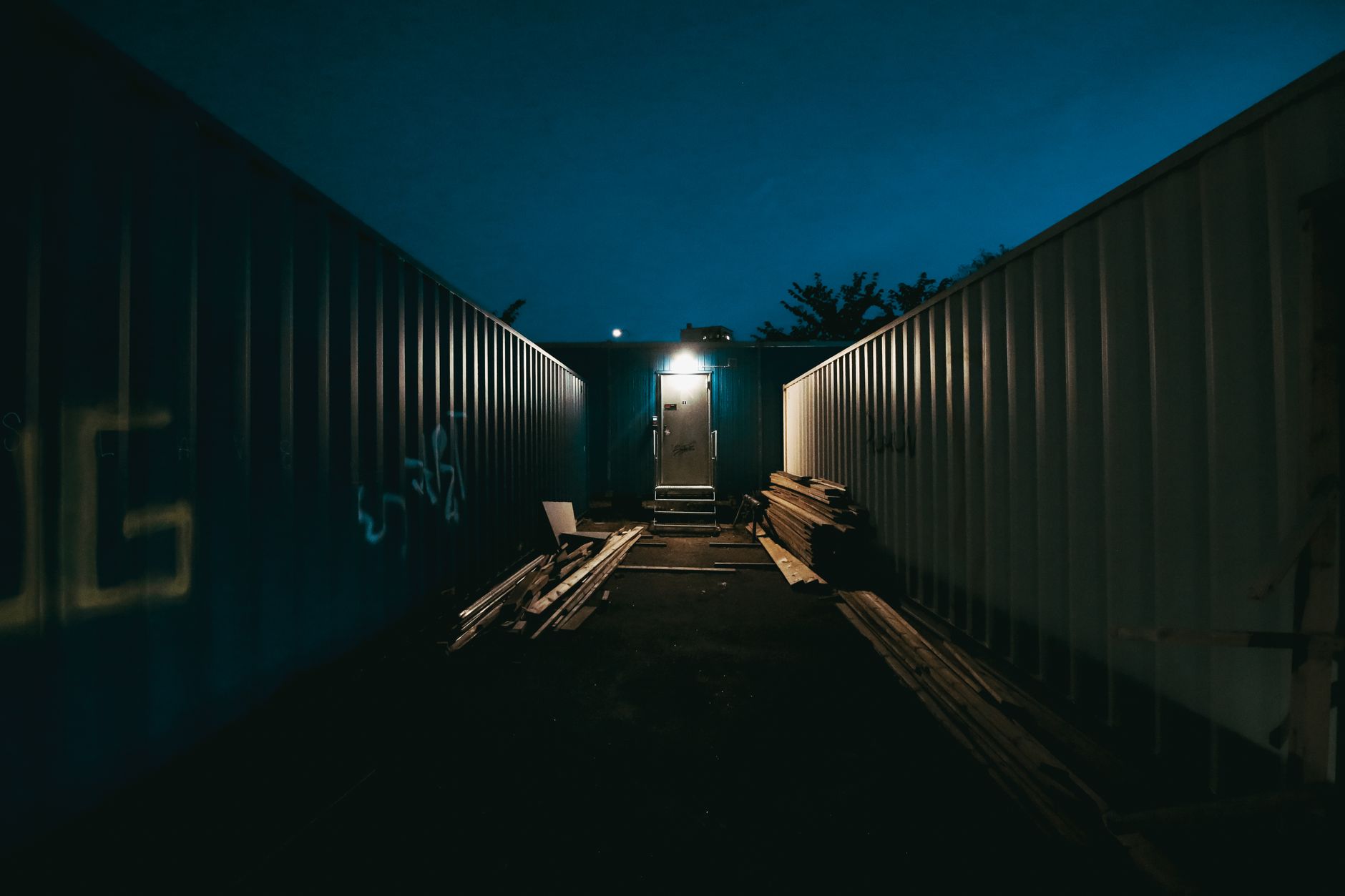 A sparsely lit outdoor storage yard showing the difficult visibility conditions of an after-hours patrol route.