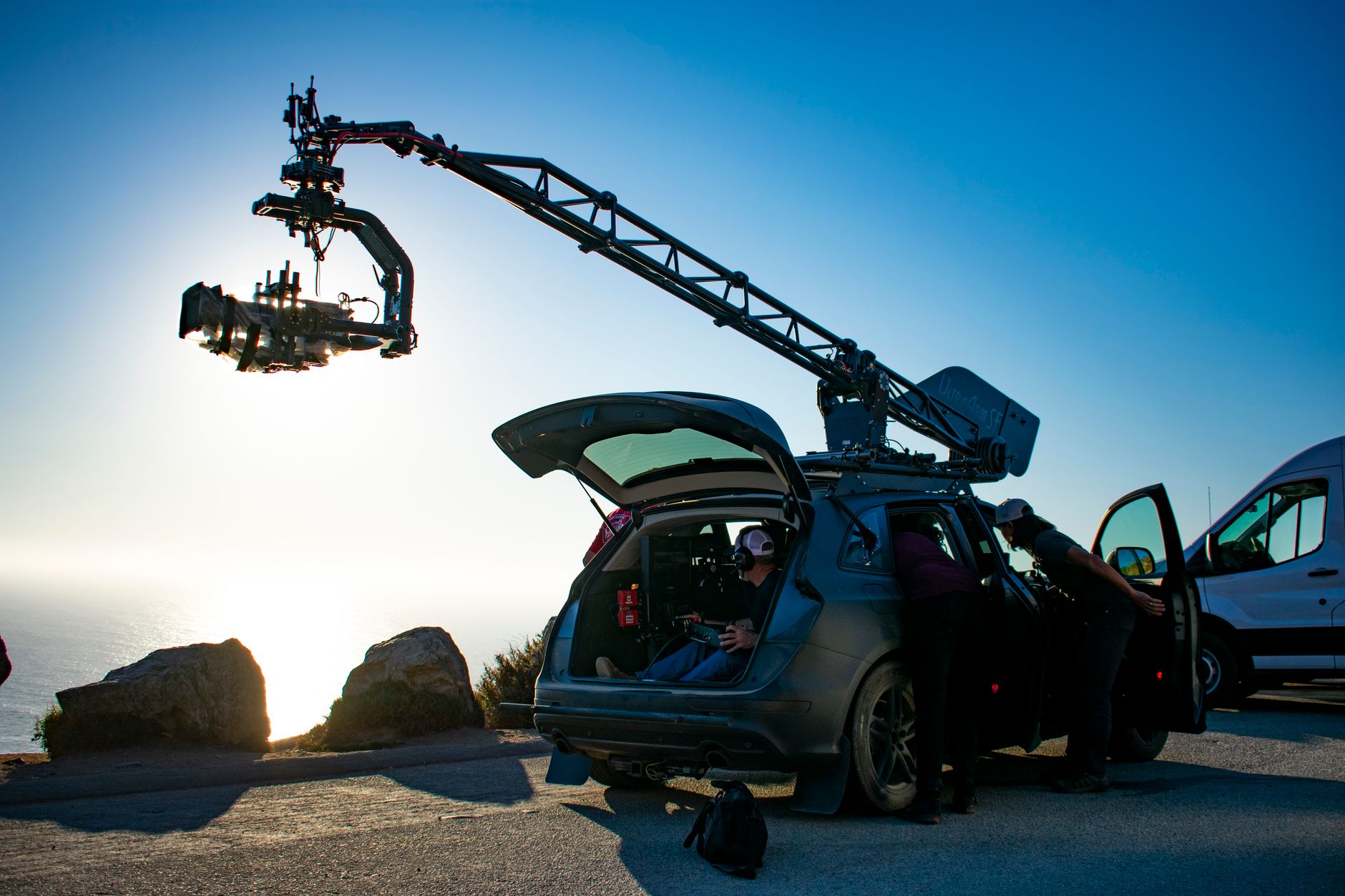 A film crew working around camera-support equipment and temporary obstacles on an active set.
