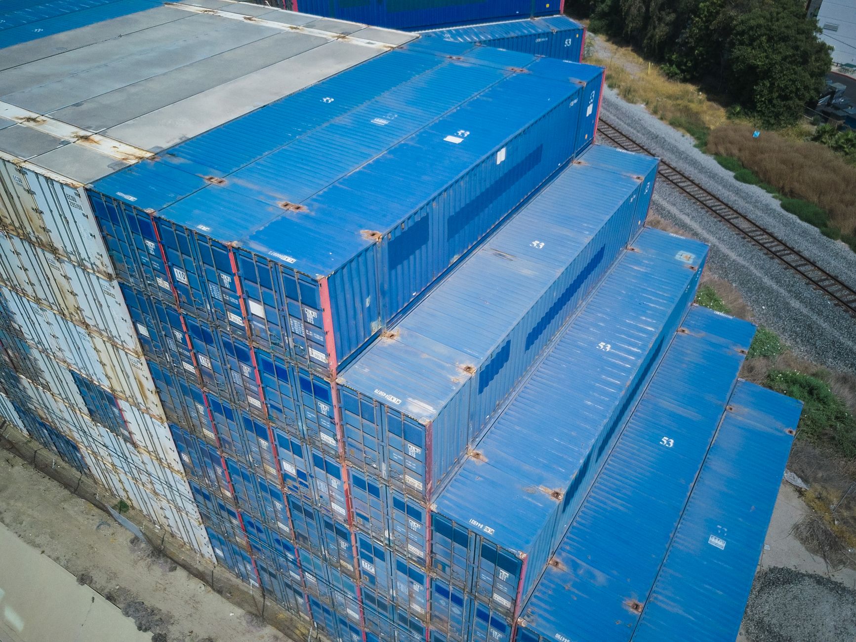 A wide aerial view of dense container stacks showing the canyons and broken sightlines common in intermodal yards.