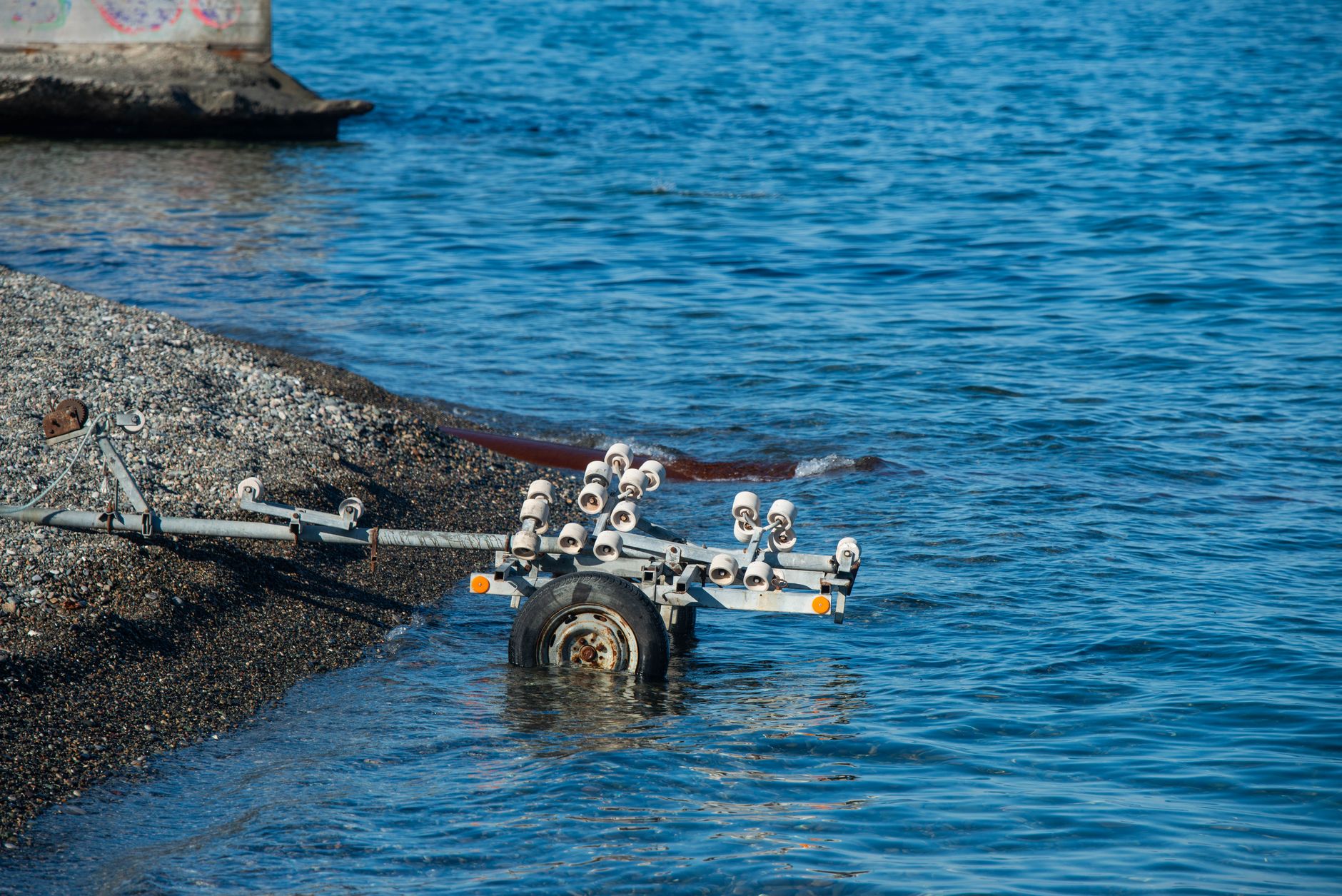 A concrete boat launch ramp and adjacent shoreline path, representing the land-side envelope where patrol coverage is often safer and more practical.