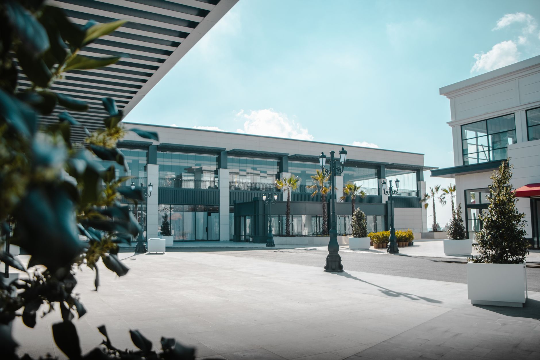 A long breezeway between open-air retail storefronts, illustrating the exposed pedestrian connectors that make outlet-center security different from an enclosed mall.