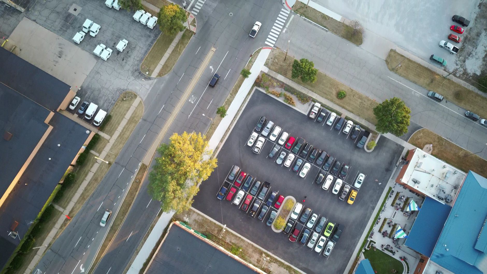 A marked pedestrian crossing in a large retail parking lot, showing the kind of vehicle and foot-traffic conflict area that stays risky after tenant close.