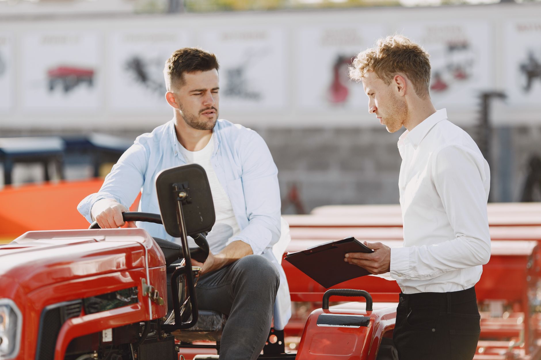 Rows of lawn tractors and compact equipment staged on an outdoor dealer lot at dusk.