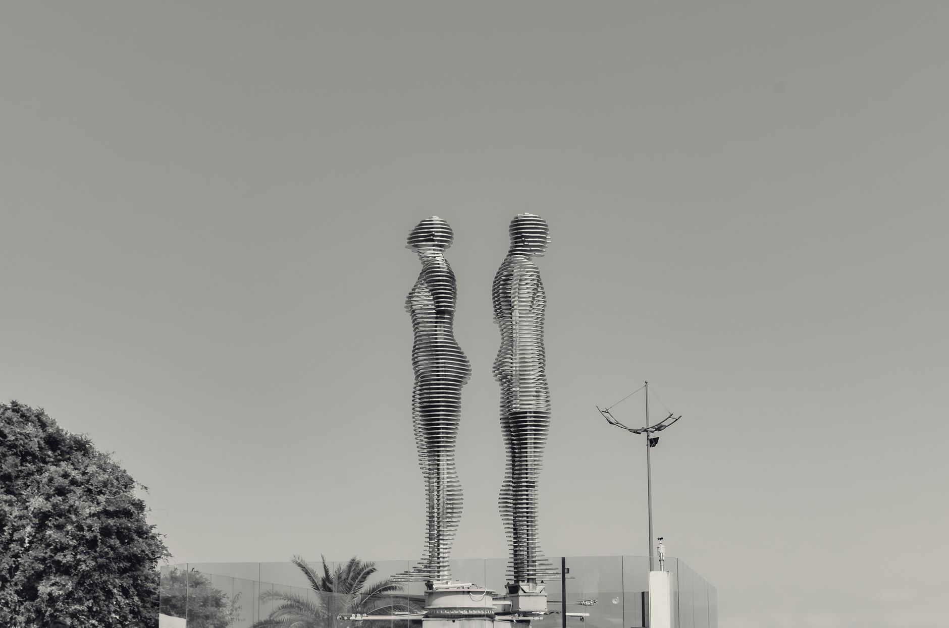 Abstract metal sculpture on a plaza, the kind of open-air piece parks fence when vandalism repeats.