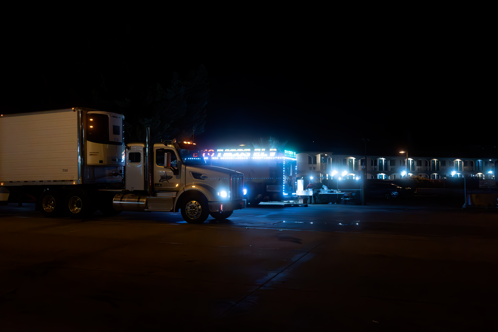 Parked freight trailers in a dark industrial yard illuminated by security lights.