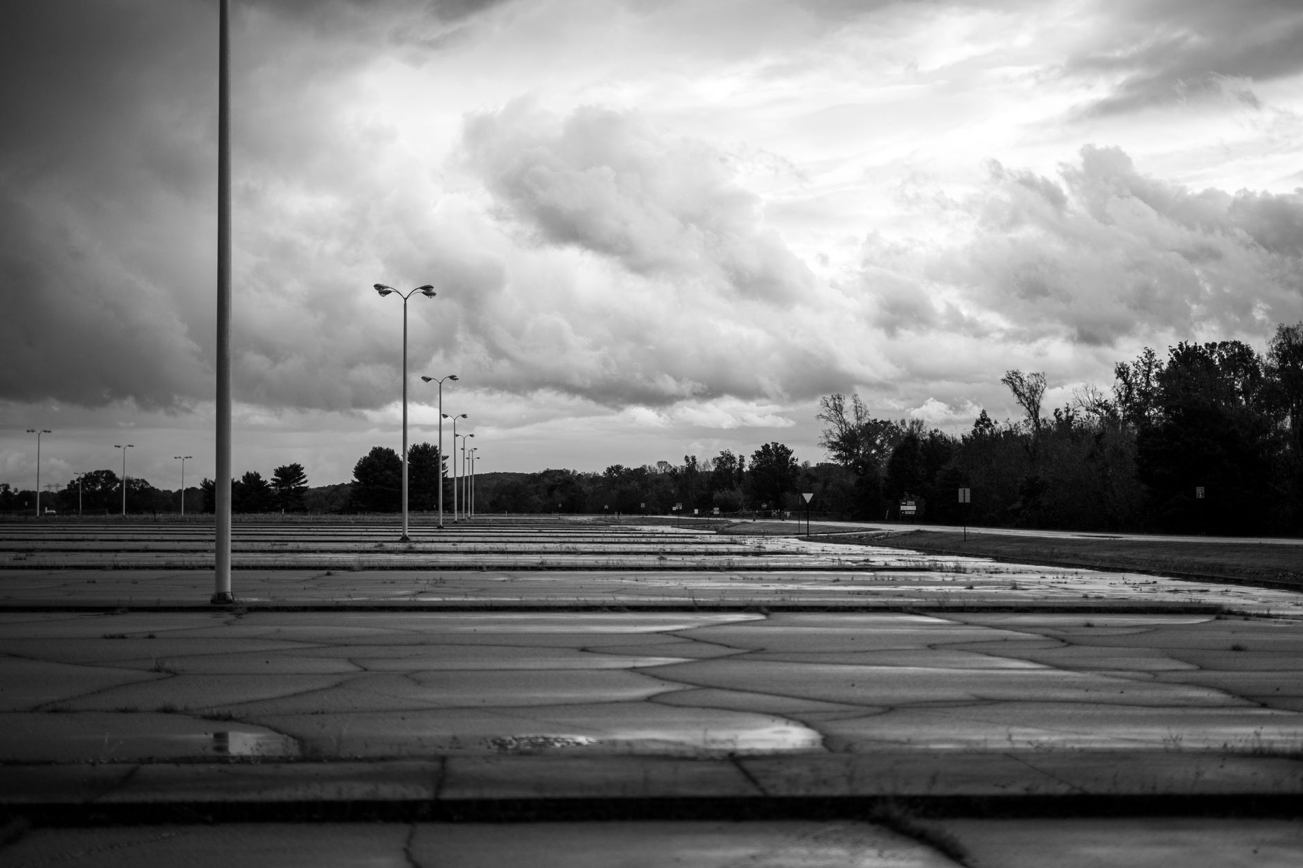 Rain-slick pavement in an open hotel parking area with parked cars.