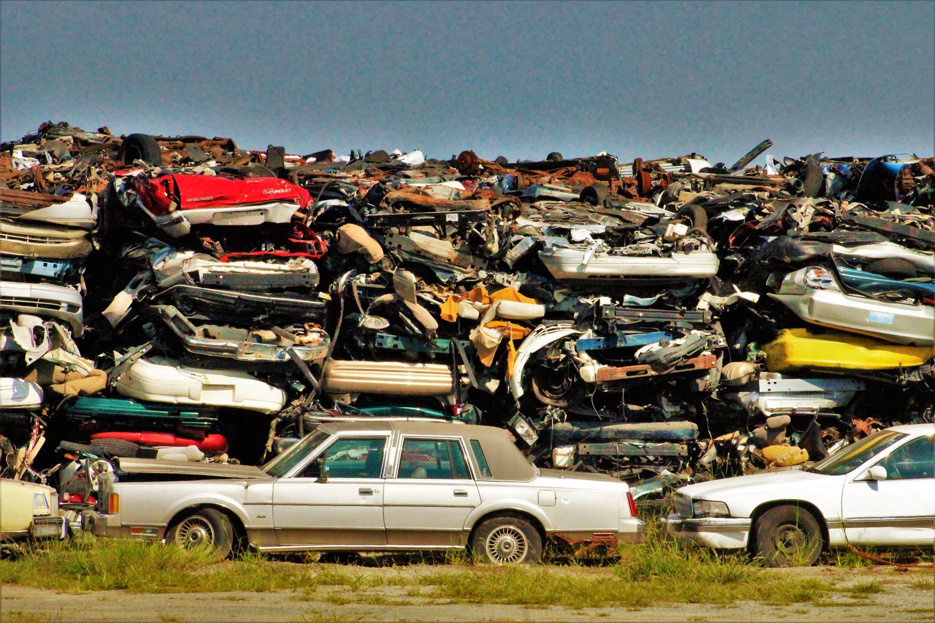 After-hours view of a large scrapyard with metal piles, fencing, and long travel lanes that show the challenge of securing a spread-out site.