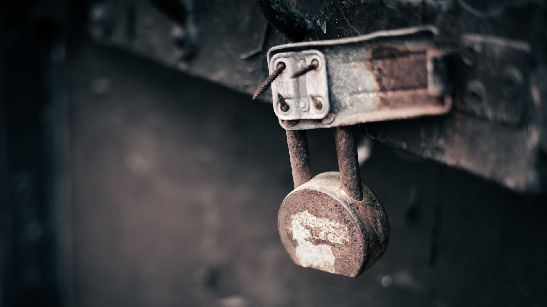A close-up of a broken or cut padlock on the ground, symbolizing the failure of traditional security measures at a storage unit.