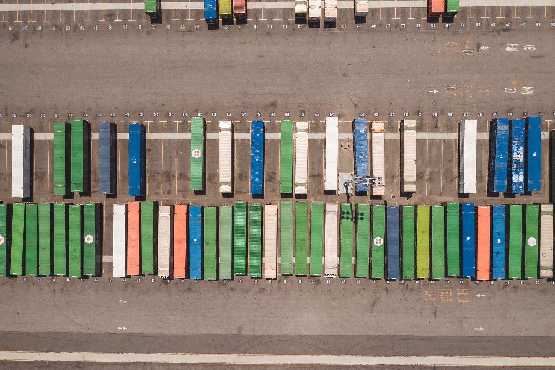 Rows of containers and detached trailers at night, showing the dark gaps and repetitive sightlines that make yard surveillance difficult.